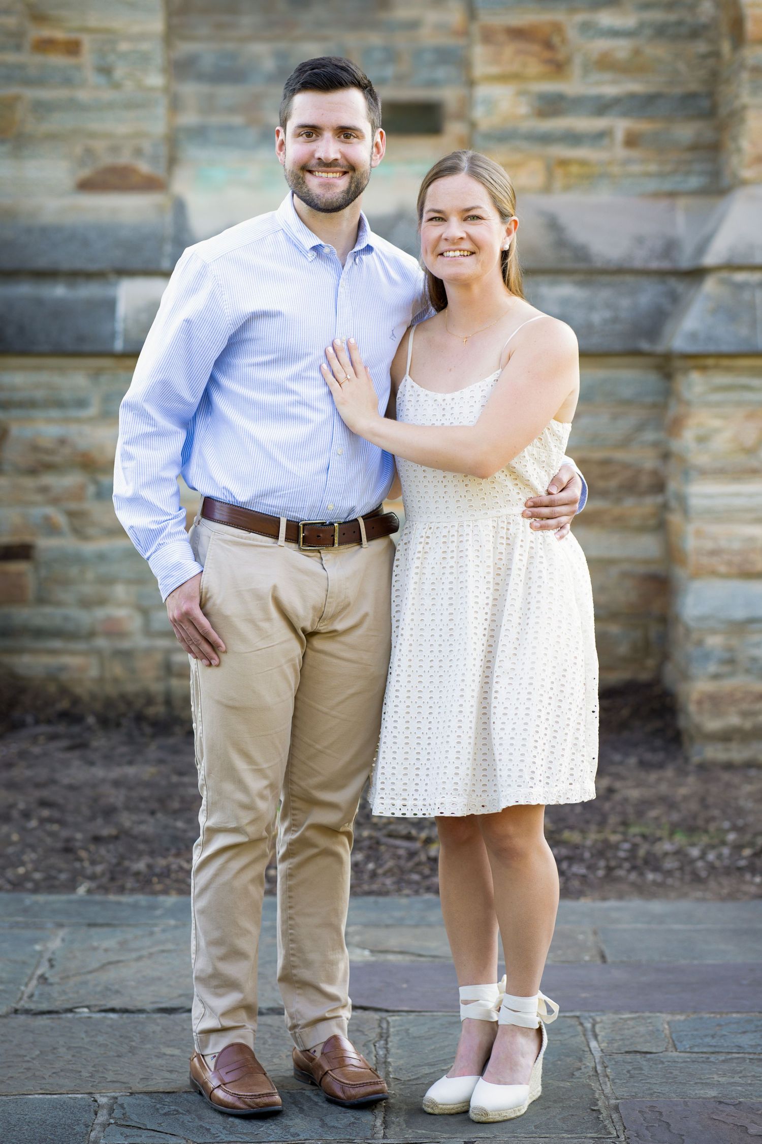A newly engaged couple laughing together during a golden hour engagement photography session.