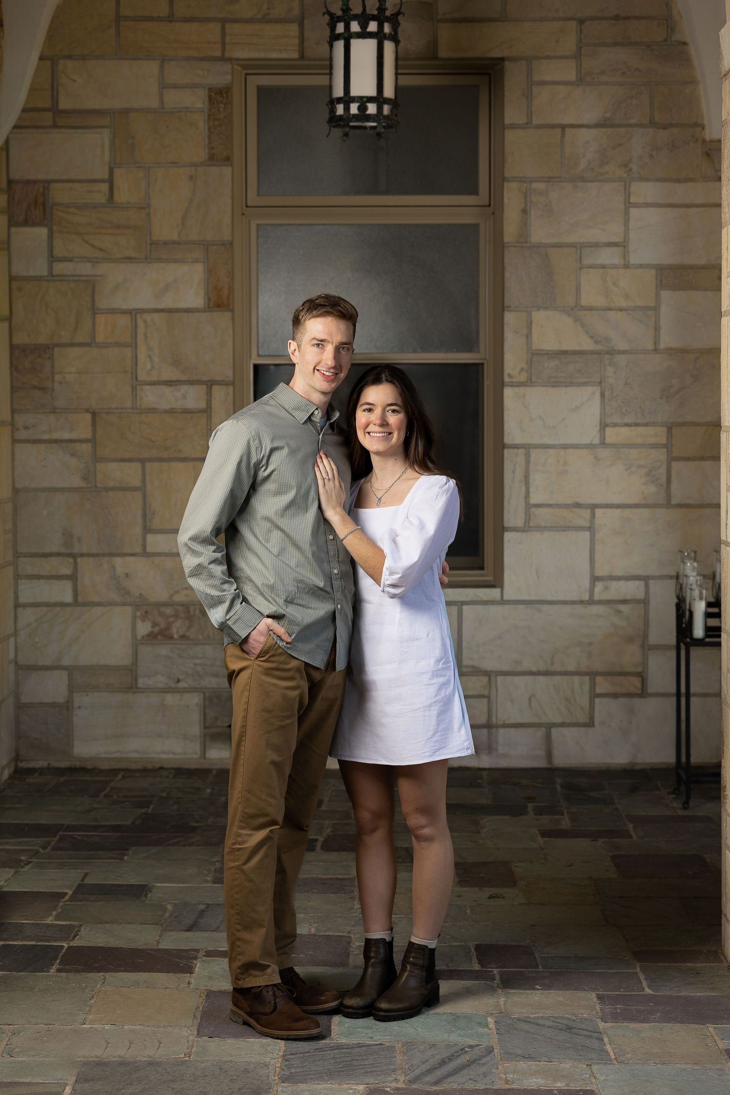 A newly engaged couple laughing together during a golden hour engagement photography session.