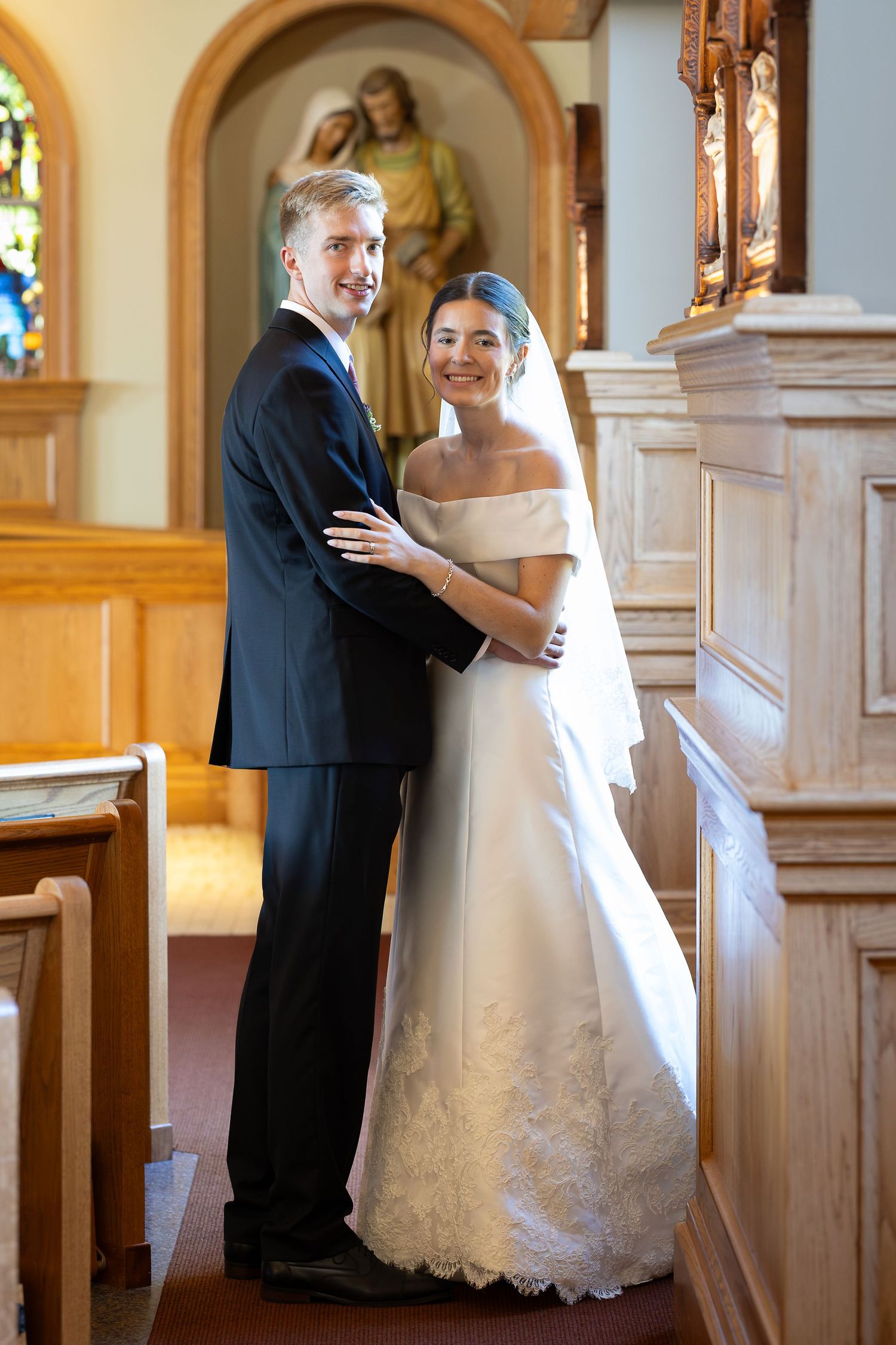 Bride and groom taking bridal portraits after the Sacrament of Holy Matrimony at a Catholic church.