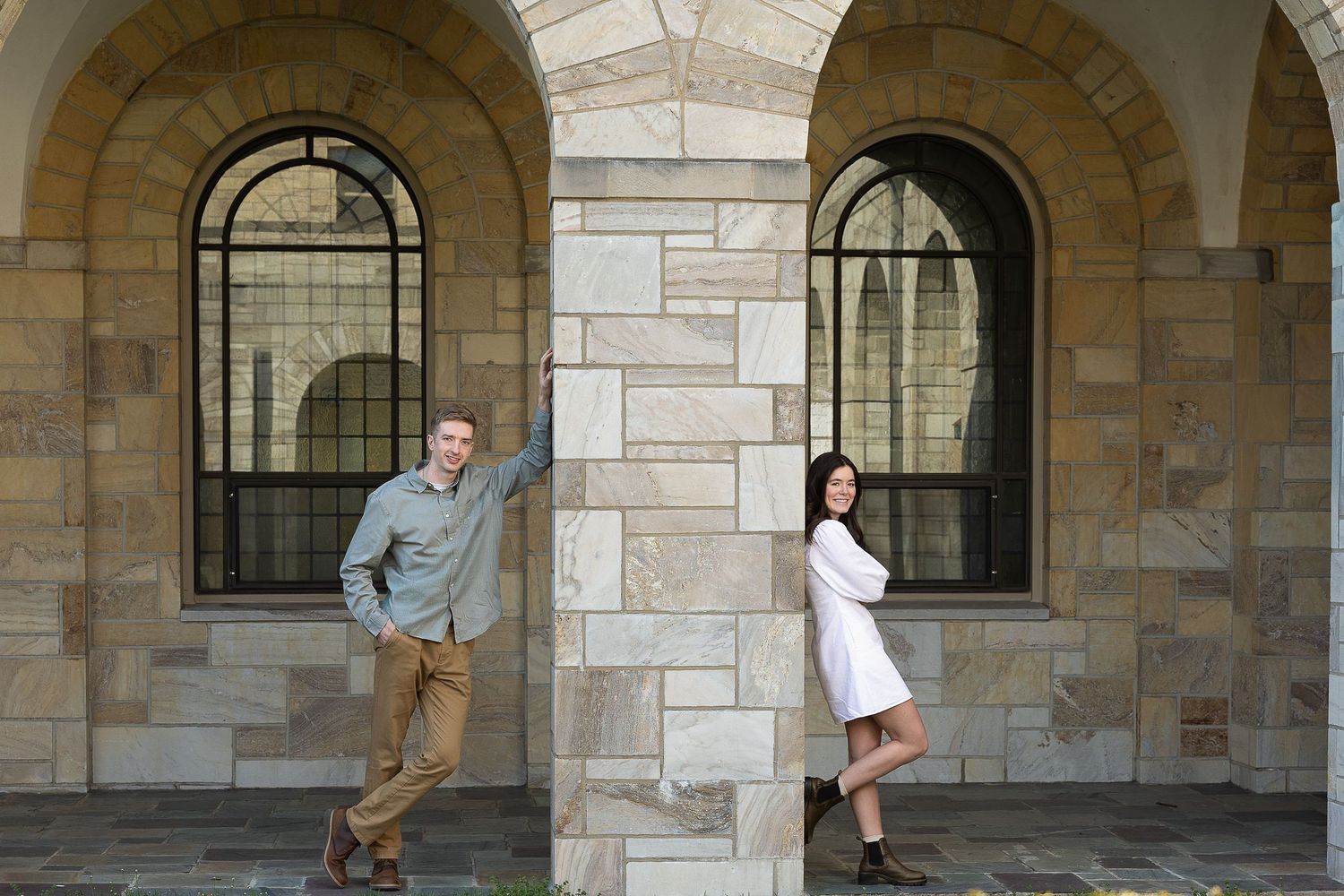A newly engaged couple laughing together during a golden hour engagement photography session.