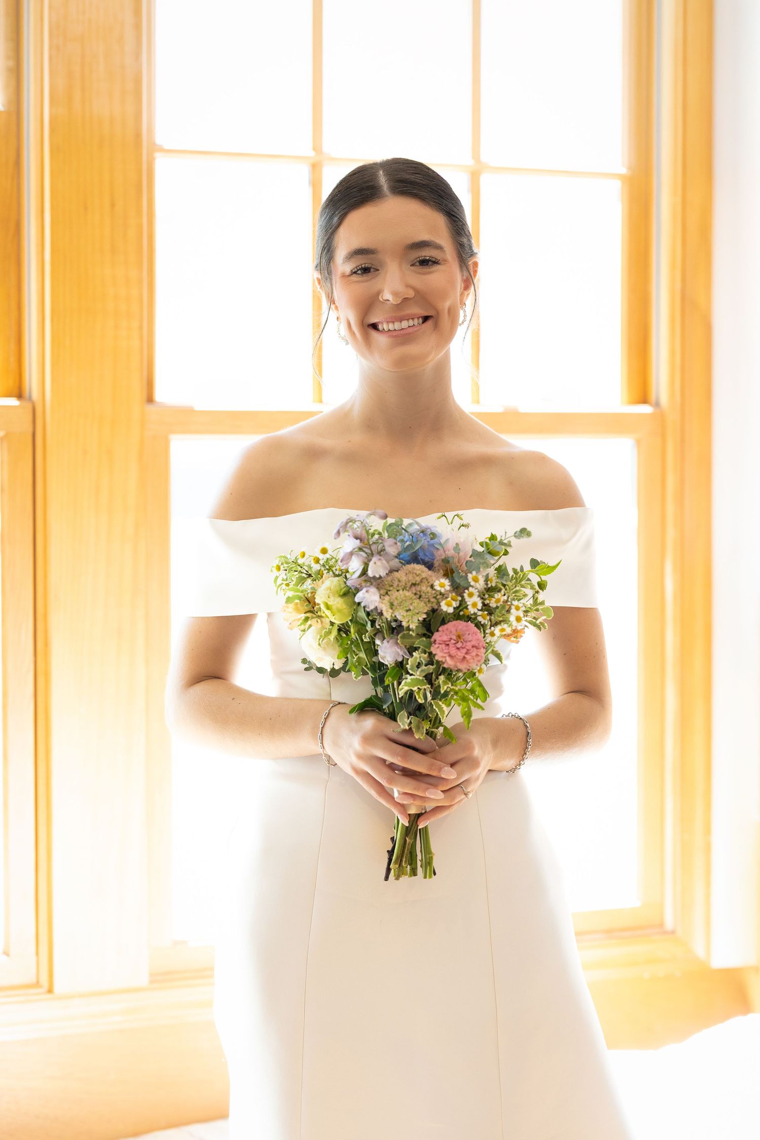 A beautiful bride standing and smiling before the Sacrament of Holy Matrimony at a Catholic church.