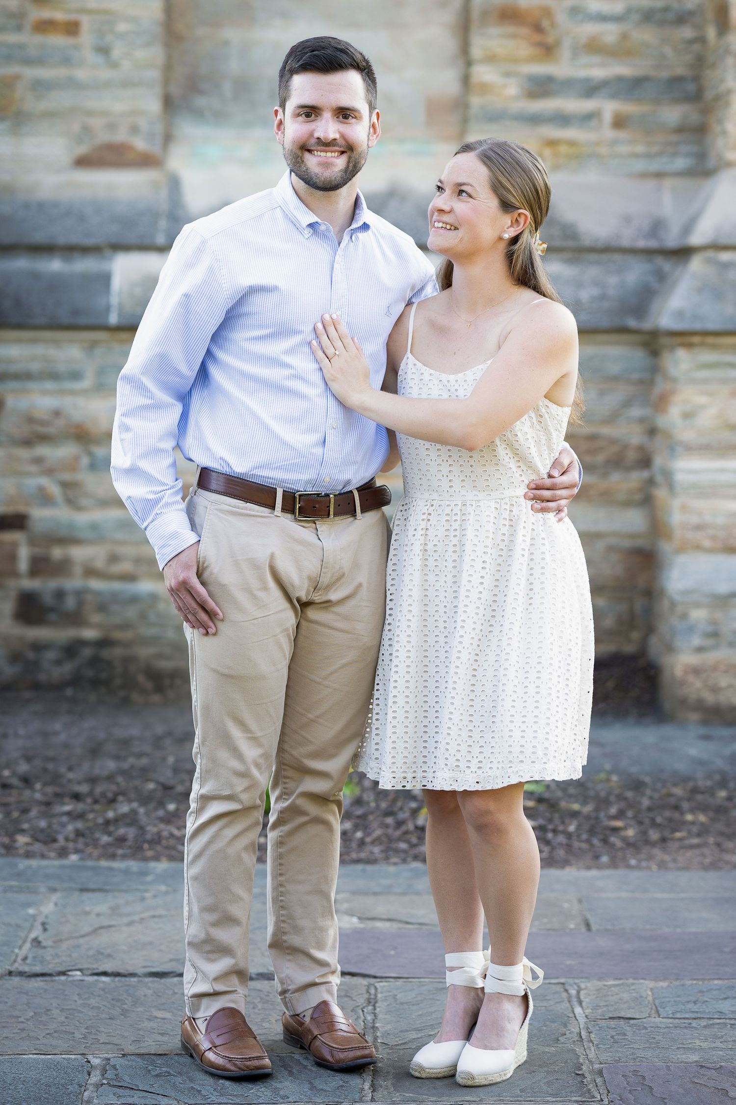 A newly engaged couple laughing together during a golden hour engagement photography session.