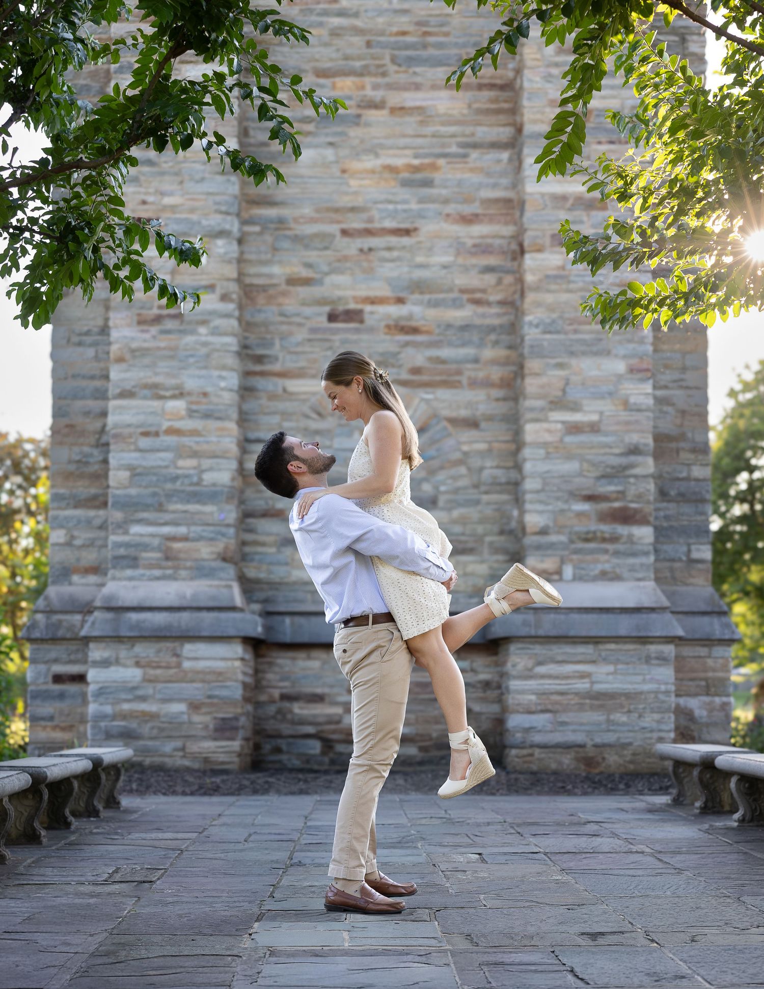 A newly engaged couple laughing together during a golden hour engagement photography session.