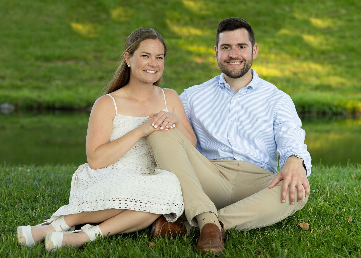 A newly engaged couple laughing together during a golden hour engagement photography session.