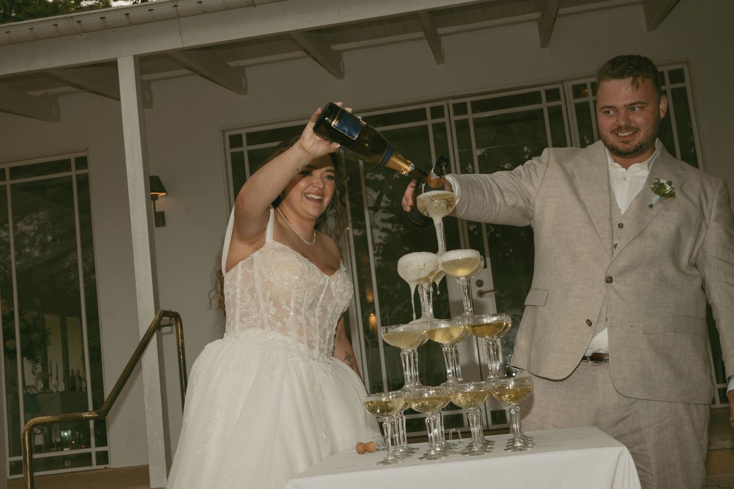 Newly married couple pouring champagne tower