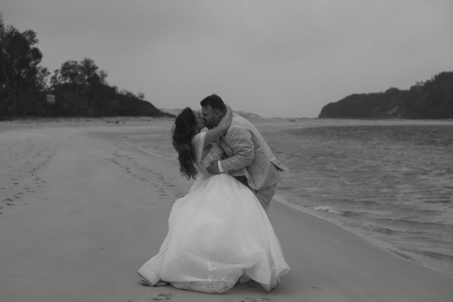 Newlyweds kissing on the beach