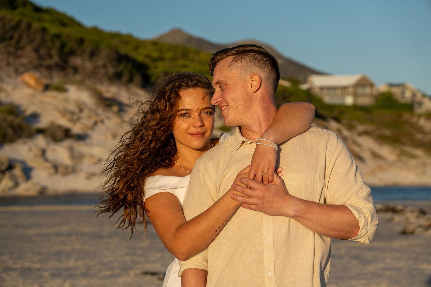 Couple embracing on the beach during a golden hour engagement photography session in Cape Town , Noordhoek Beach