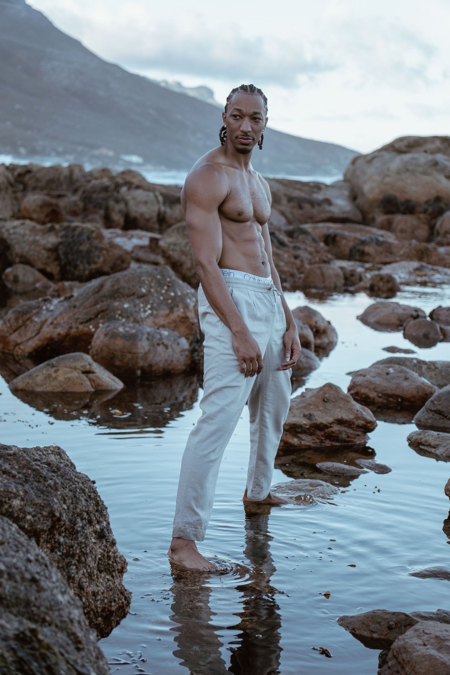 Male lifestyle portrait photographed among coastal rocks and tidal pools in Cape Town by Charlene Vrey Photography.
