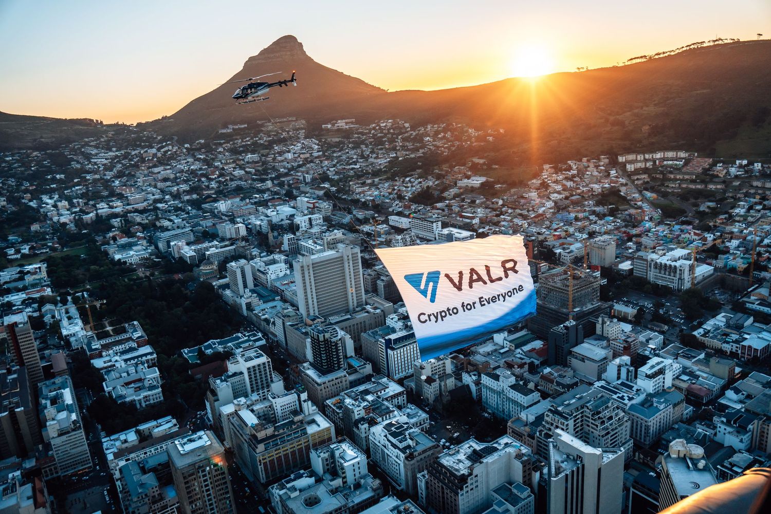 Aerial photography over Cape Town at sunset featuring a branded VALR Crypto billboard and Lion’s Head in the background.