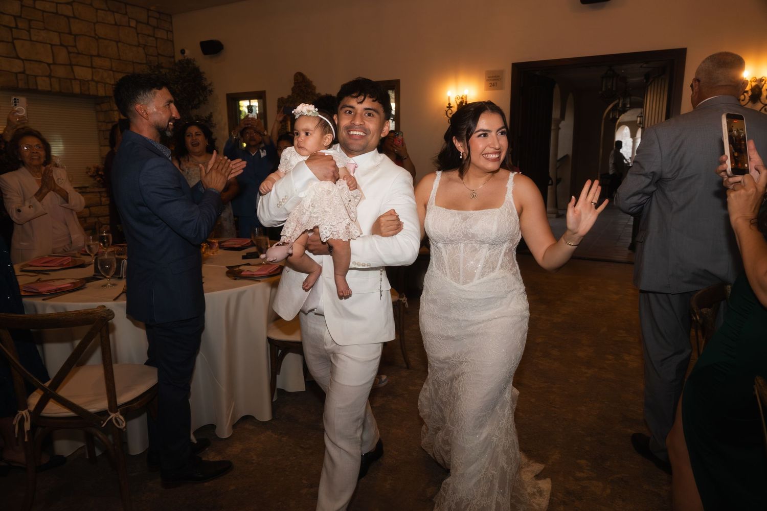 Emmanuel Pacquiao and wife Carolina Pimentel Pacquiao making grand reception entrance with baby as guests cheer in rustic venue.