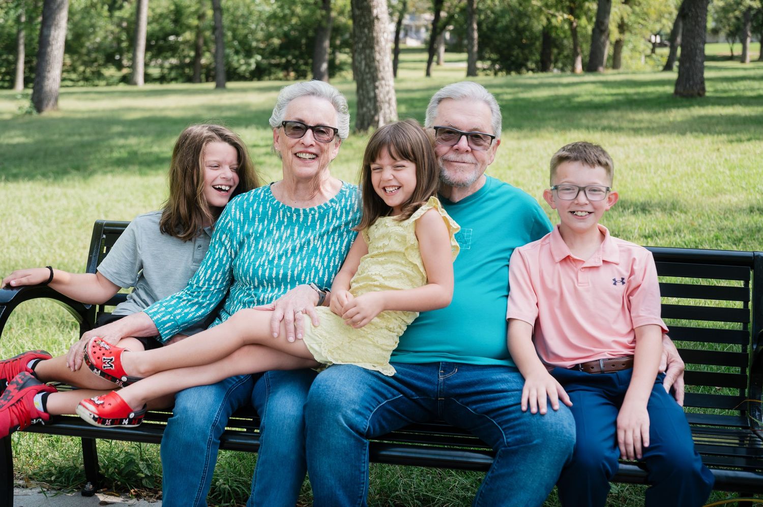 Grandparents laughing with their grandchildren during a family photo session at Walnut Grove Park in Omaha