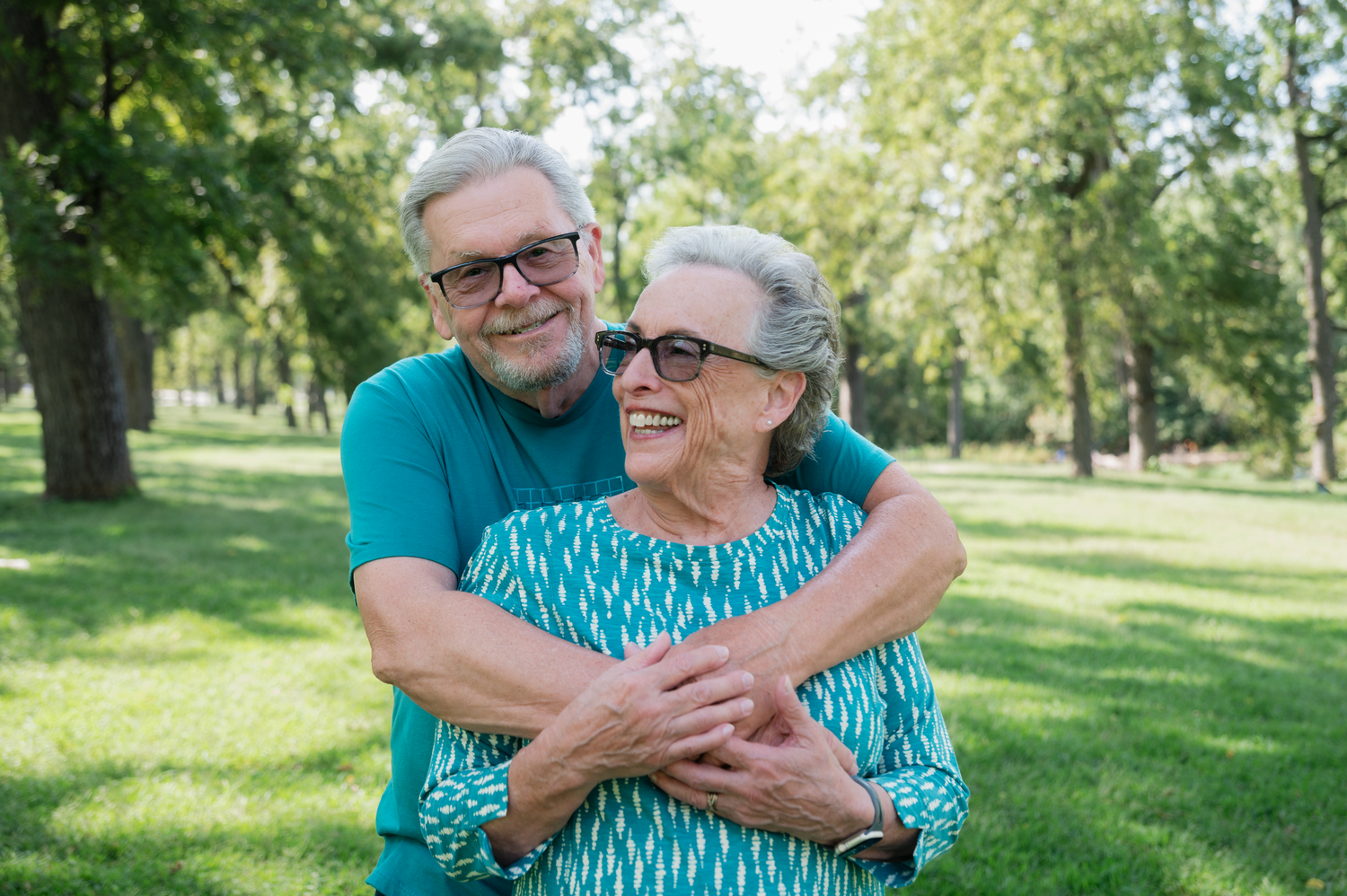 Husband embracing his wife during an anniversary photo session at Walnut Grove Park in Omaha