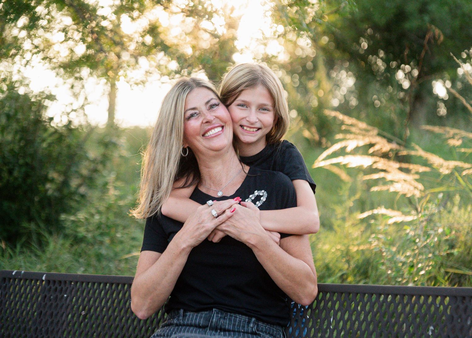 Mother and daughter embracing during an outdoor family photography session at Chalco Hills in Omaha