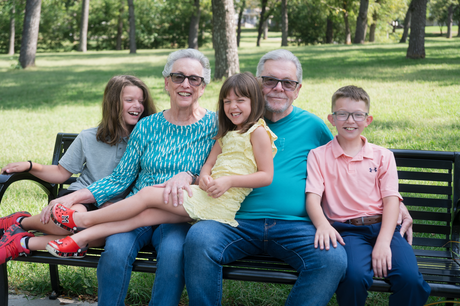 Grandparents with three grandchildren during a family photo session at Walnut Grove Park in Omaha