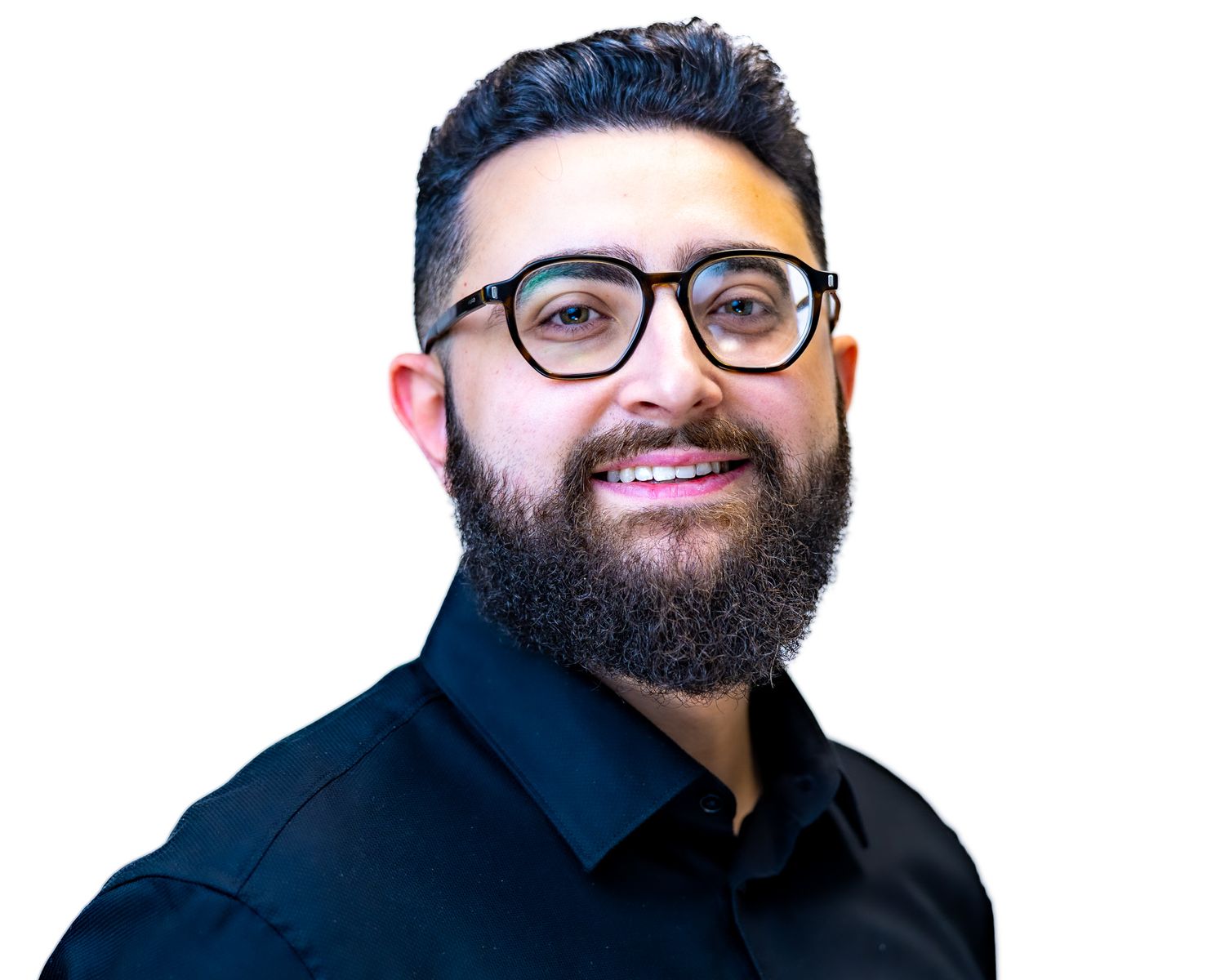 Professional portrait of someone in a navy shirt and black-rimmed glasses smiling warmly against a white background.