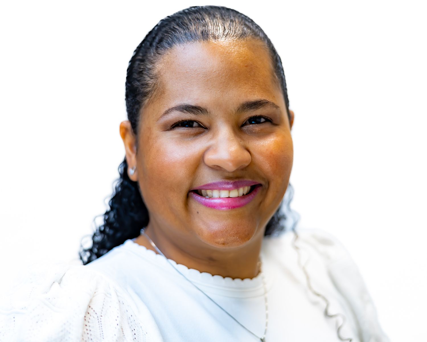 Professional headshot with a bright smile wearing a white sweater against a light background.
