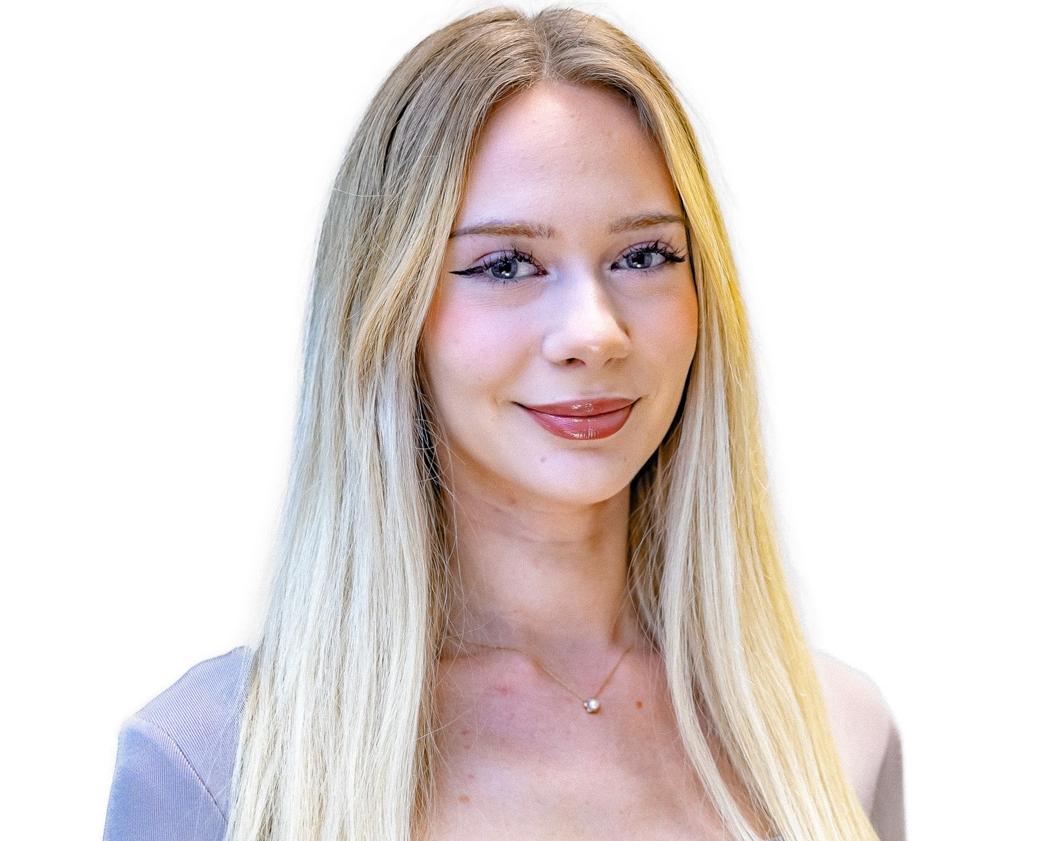 A young woman with long blonde hair and subtle makeup wearing a light colored top smiles at the camera.
