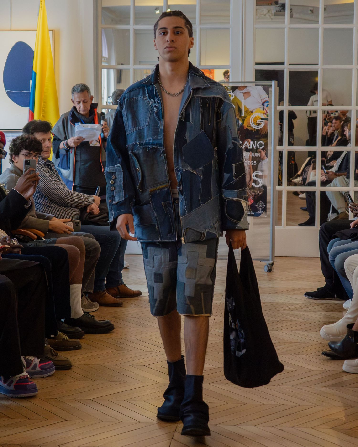 People wearing denim outfits and casual clothes wait in a modern indoor space with wood floors and bright lighting.
