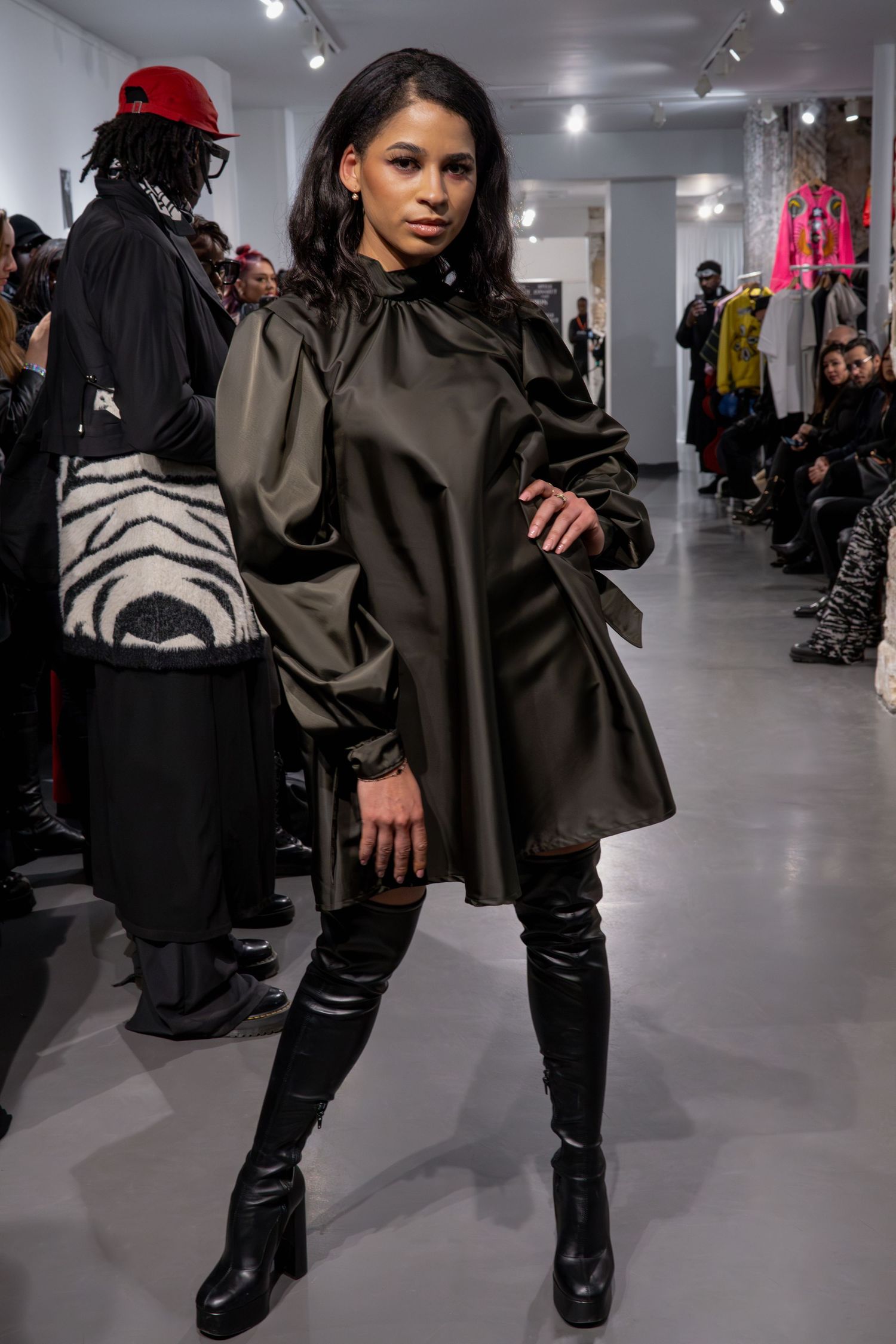 Robe noire à la mode avec des bottes jusqu'aux genoux sur un modèle de défilé pour la Paris Fashion Week.