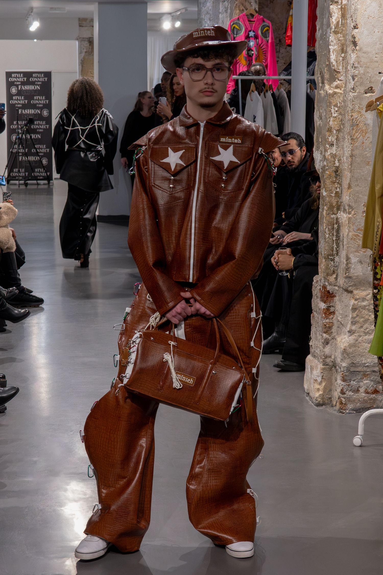 Tenue en cuir marron avec détails étoiles et sac à main assorti présenté lors d'une présentation de mode lors de la Paris Fashion Week.