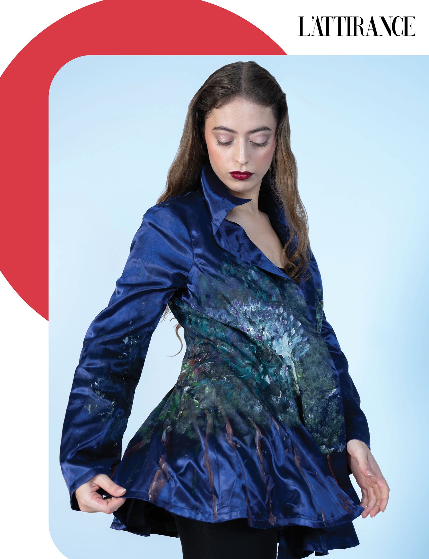 Photographie Mannequin portant une veste noire à imprimé floral pose sur un fond bleu clair avec un cadre rouge pour le magazine L'attirance