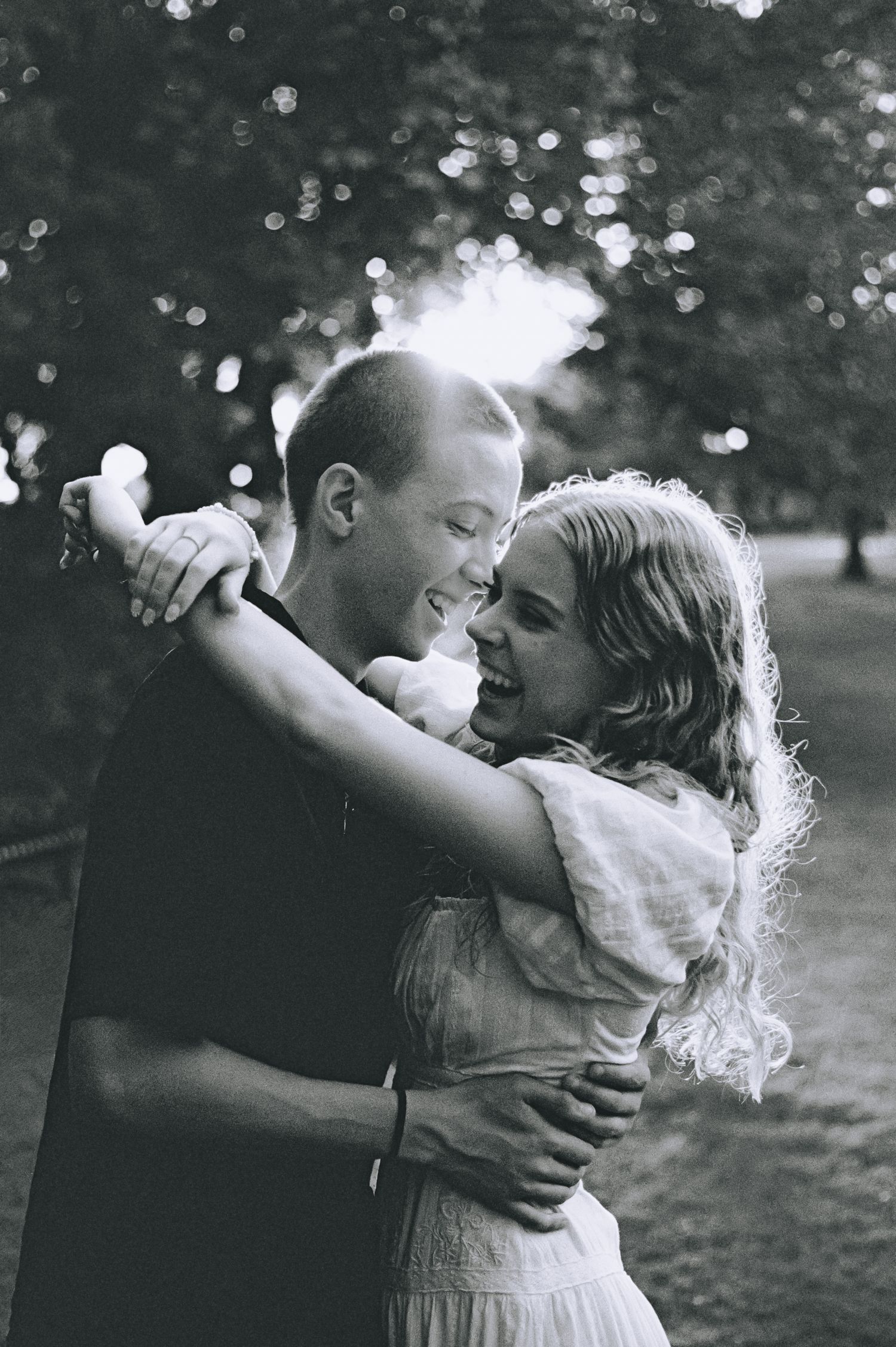 A heartwarming black and white photo sequence shows a tender embrace and playful moment outdoors in a park setting.