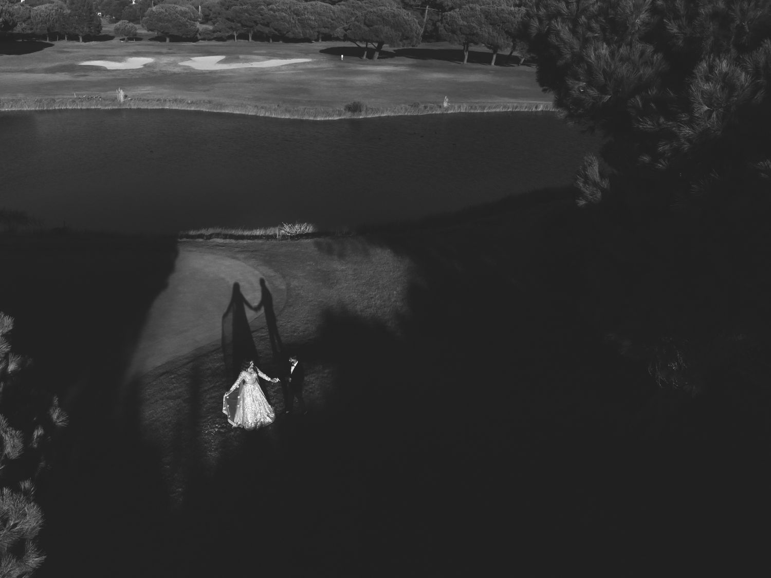 Black and white aerial portrait of Indian newlyweds at Onyria Hotel green in Portugal