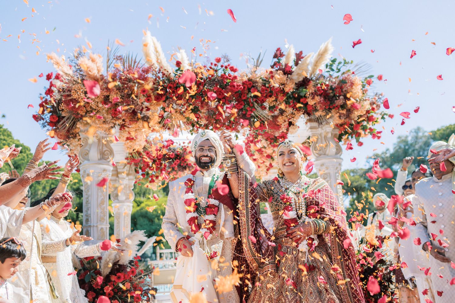 indian couple exiting their mandap ceremony surrounded by flower petals at Indian destination wedding in Cascais, Portugal