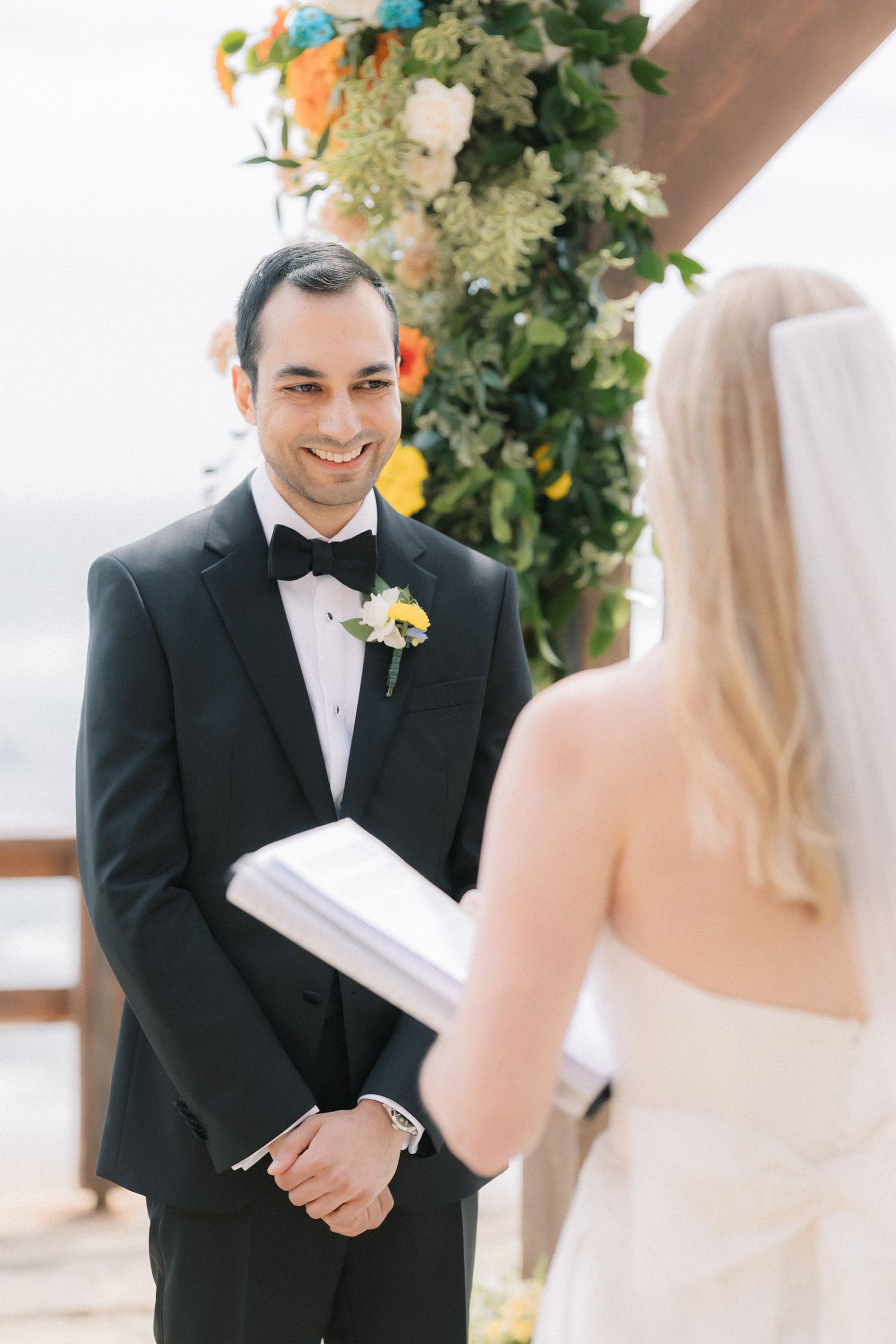 Bride and groom exchanging vows during an outdoor wedding ceremony overlooking the Atlantic Ocean in Cascais.