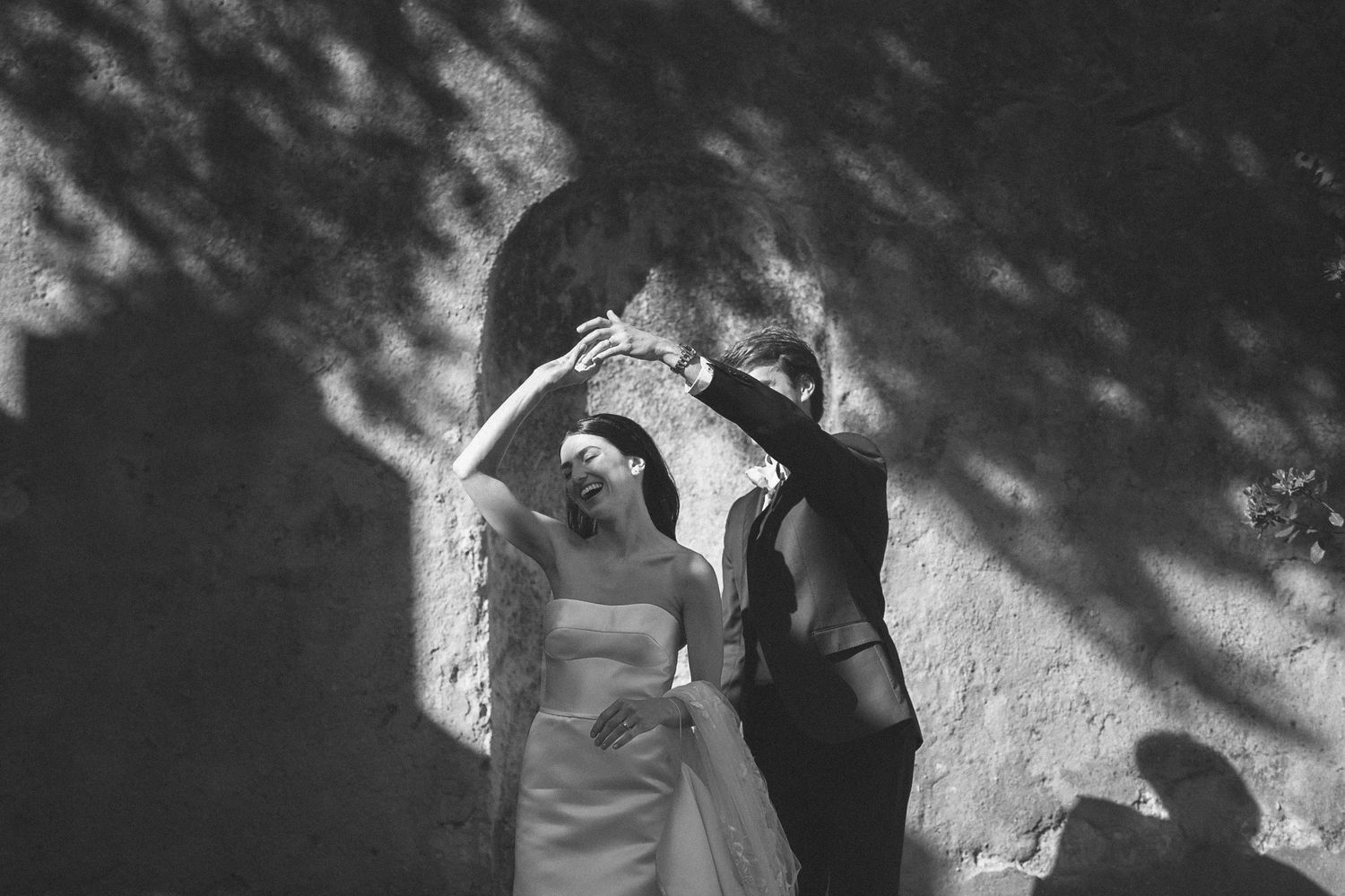 Romantic black and white portrait of a bride and groom dancing in soft light and shadows during a destination wedding at Penha Longa Resort,