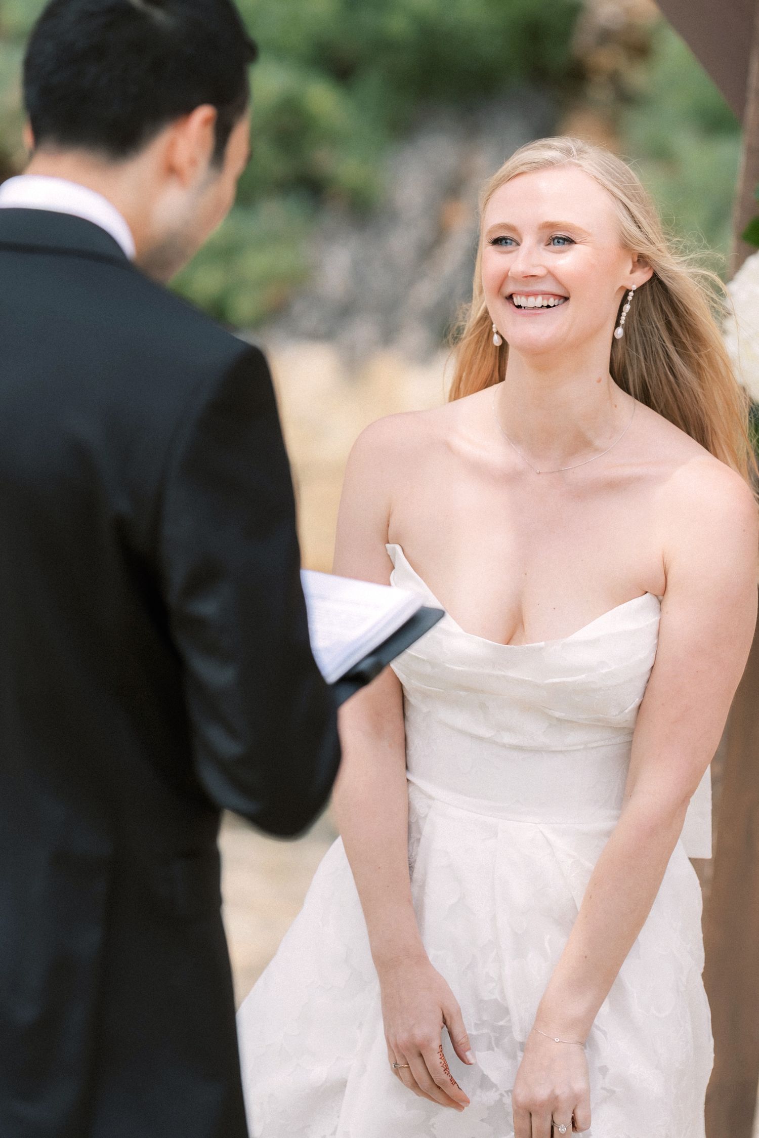 Bride smiling during her emotional wedding ceremony by the sea in Portugal.