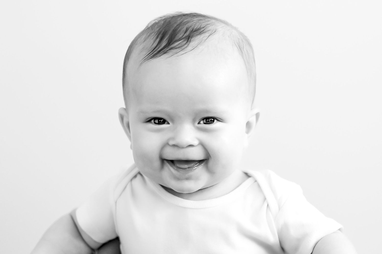 Collection of black and white baby portraits showing happy expressions.