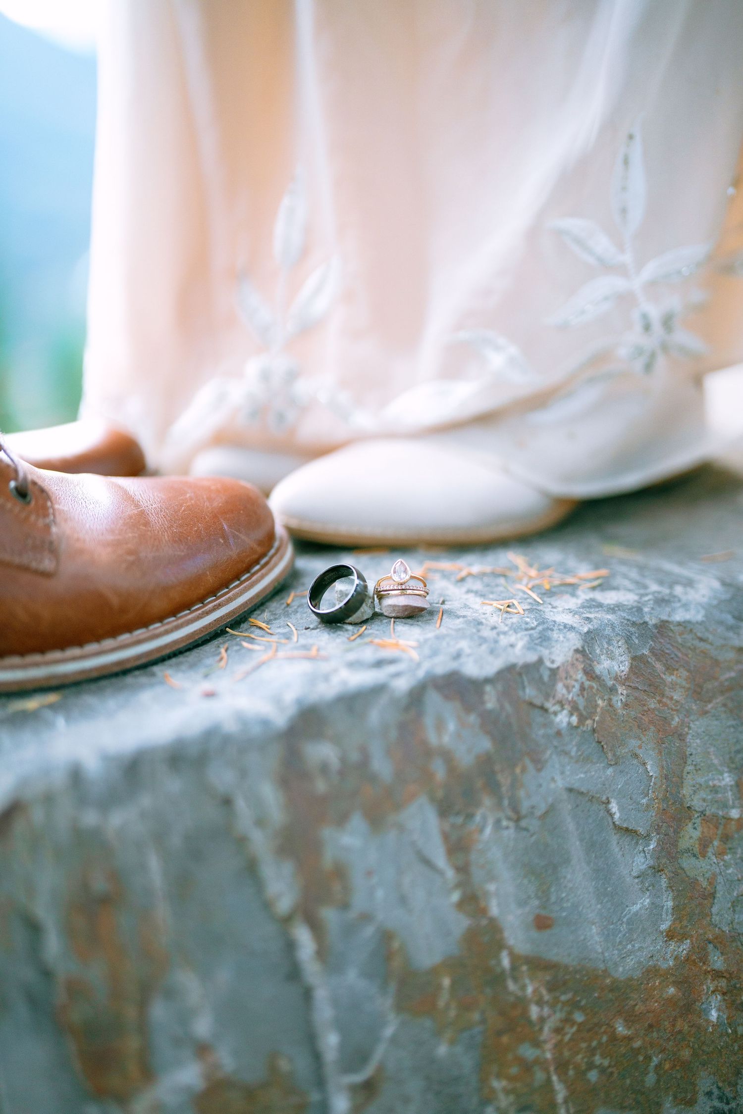 Wedding rings and hiking boots celebrating an adventurous Glacier National Park elopement.