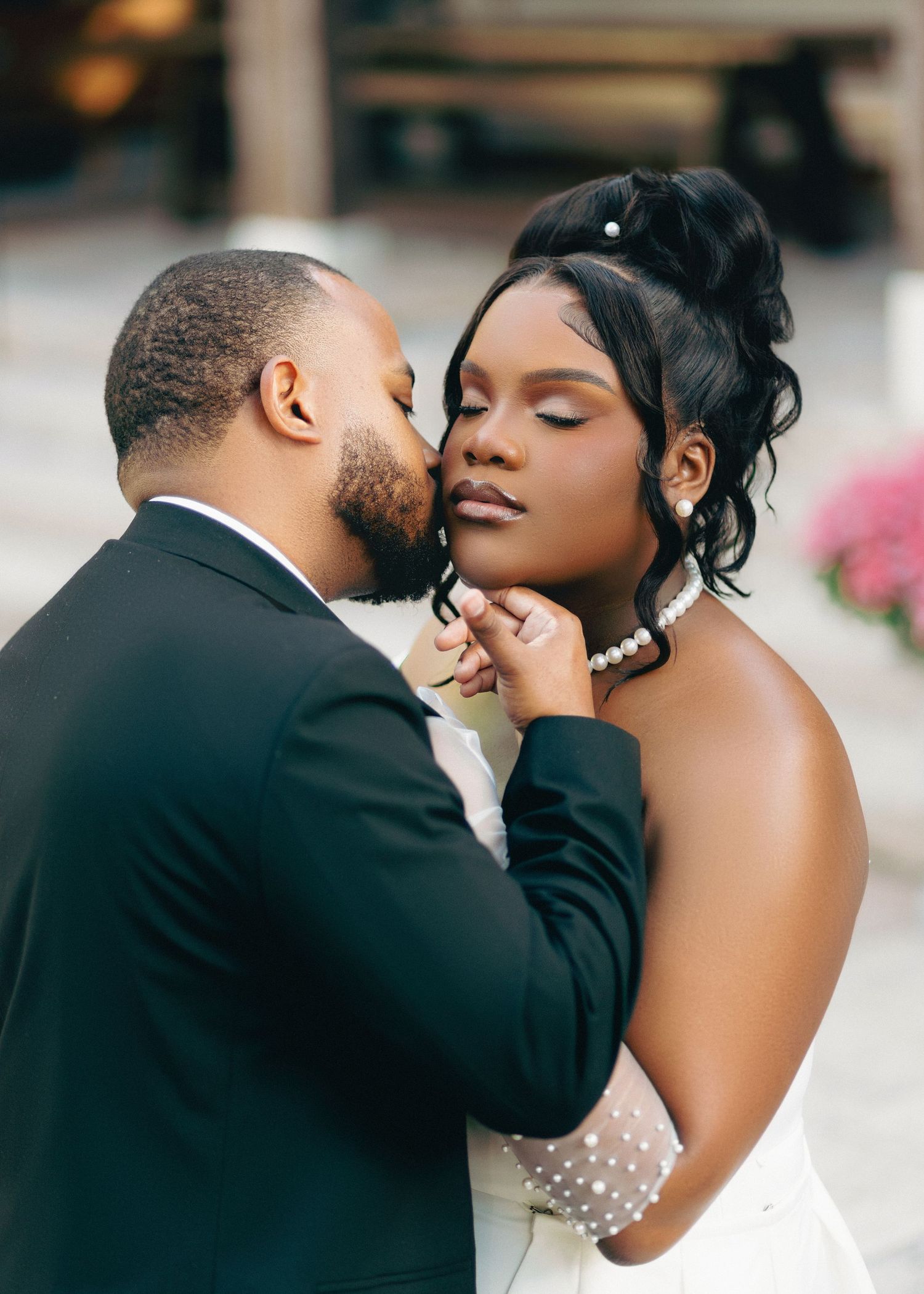 A romantic moment between a couple in formal wedding attire sharing an intimate embrace.
