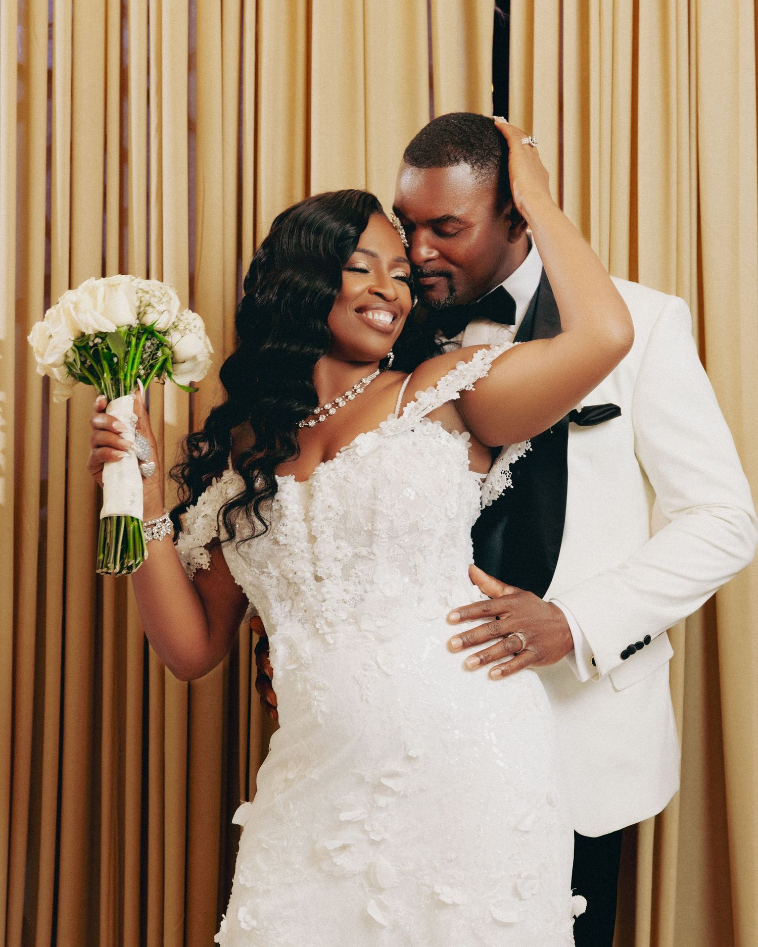 Newlyweds share romantic dance moments against golden curtain backdrop at reception.