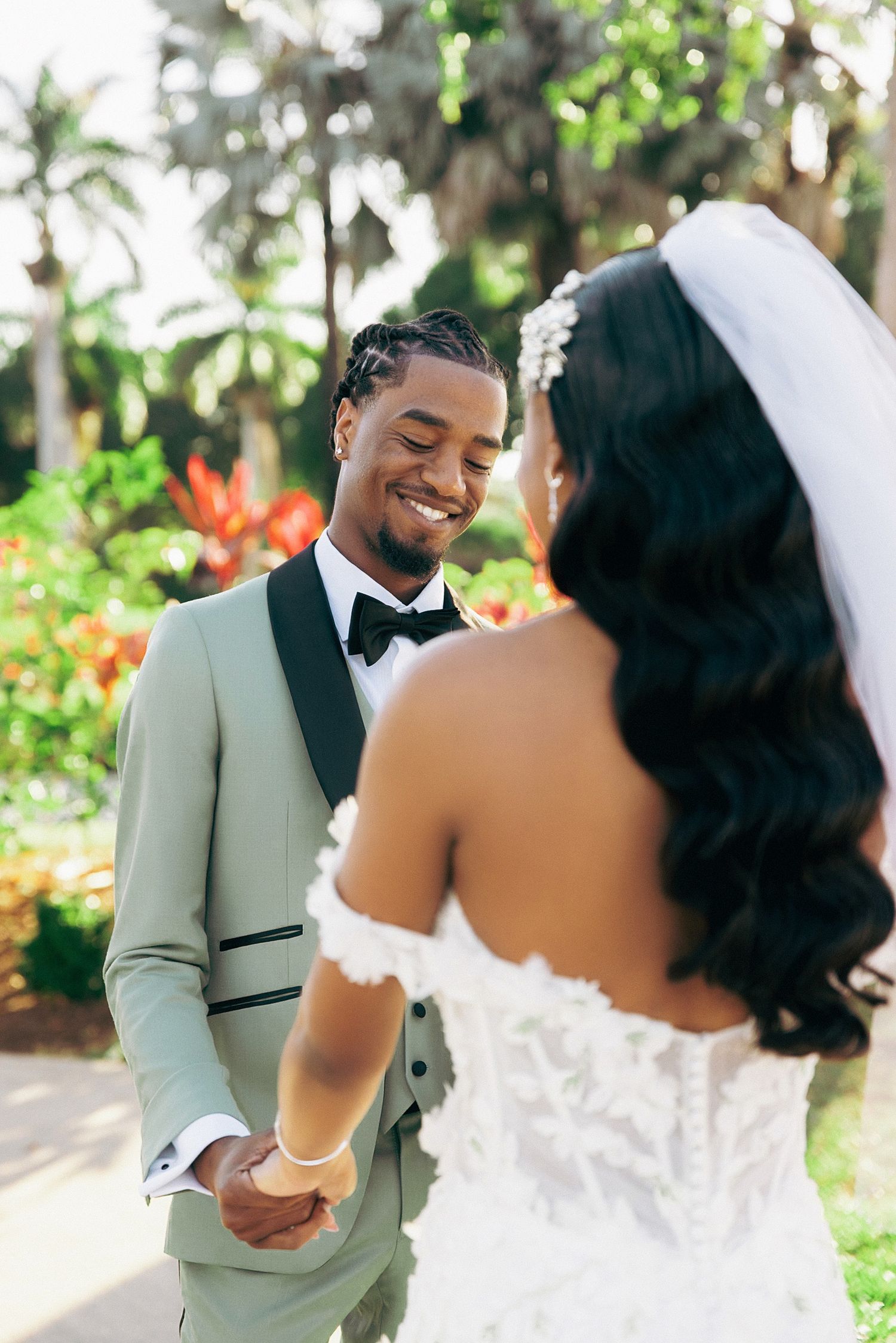 A joyful wedding couple shares intimate moments during their outdoor garden photoshoot.