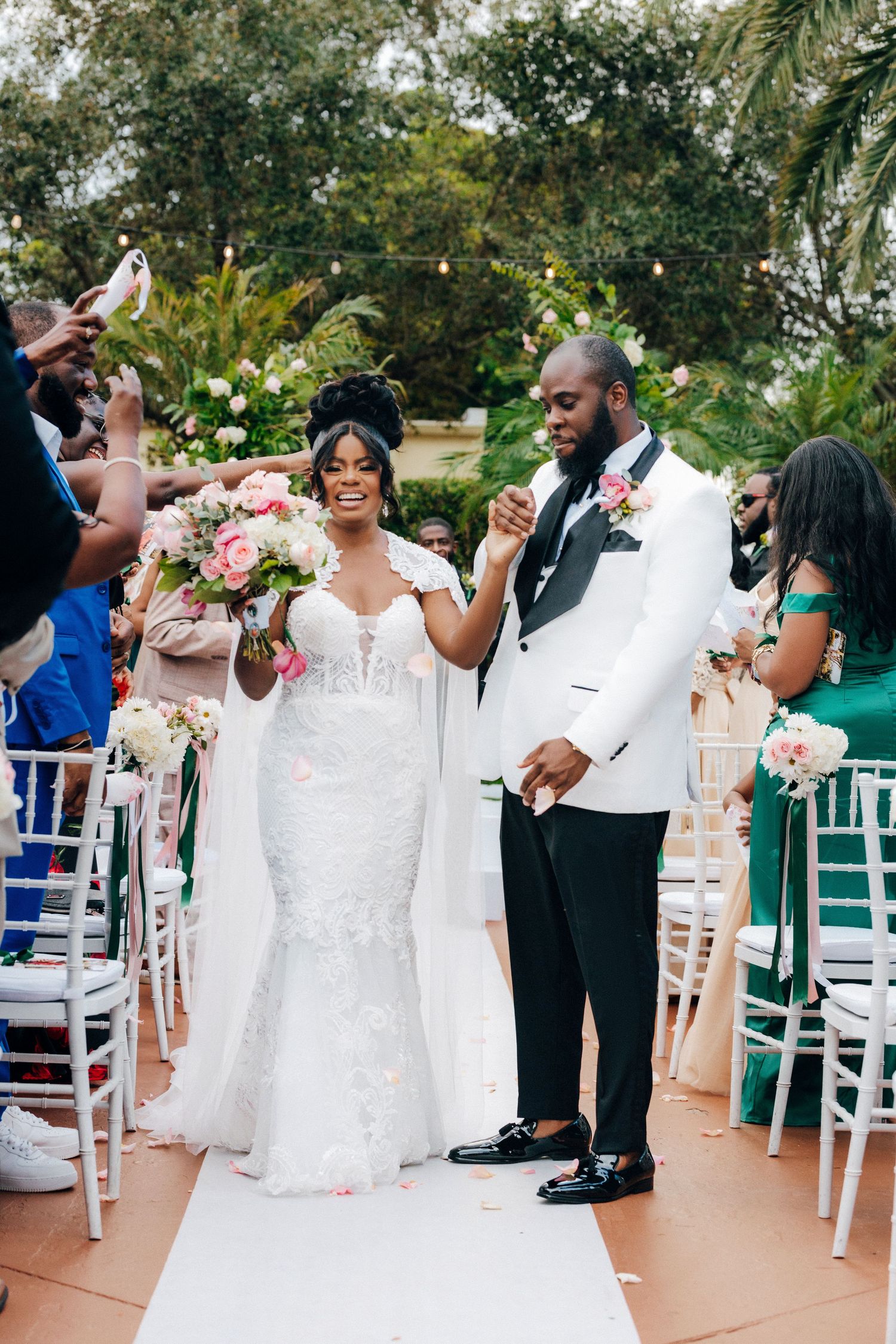 Wedding celebration on an outdoor patio with guests in formal attire dancing and enjoying festivities.