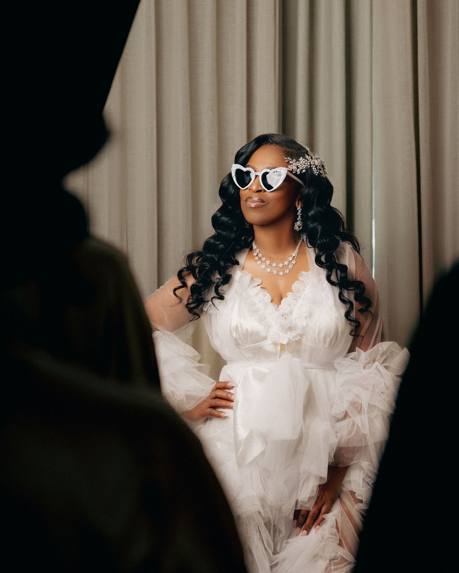 Artistic bridal photoshoot with dramatic lighting and elegant white ruffled dress.