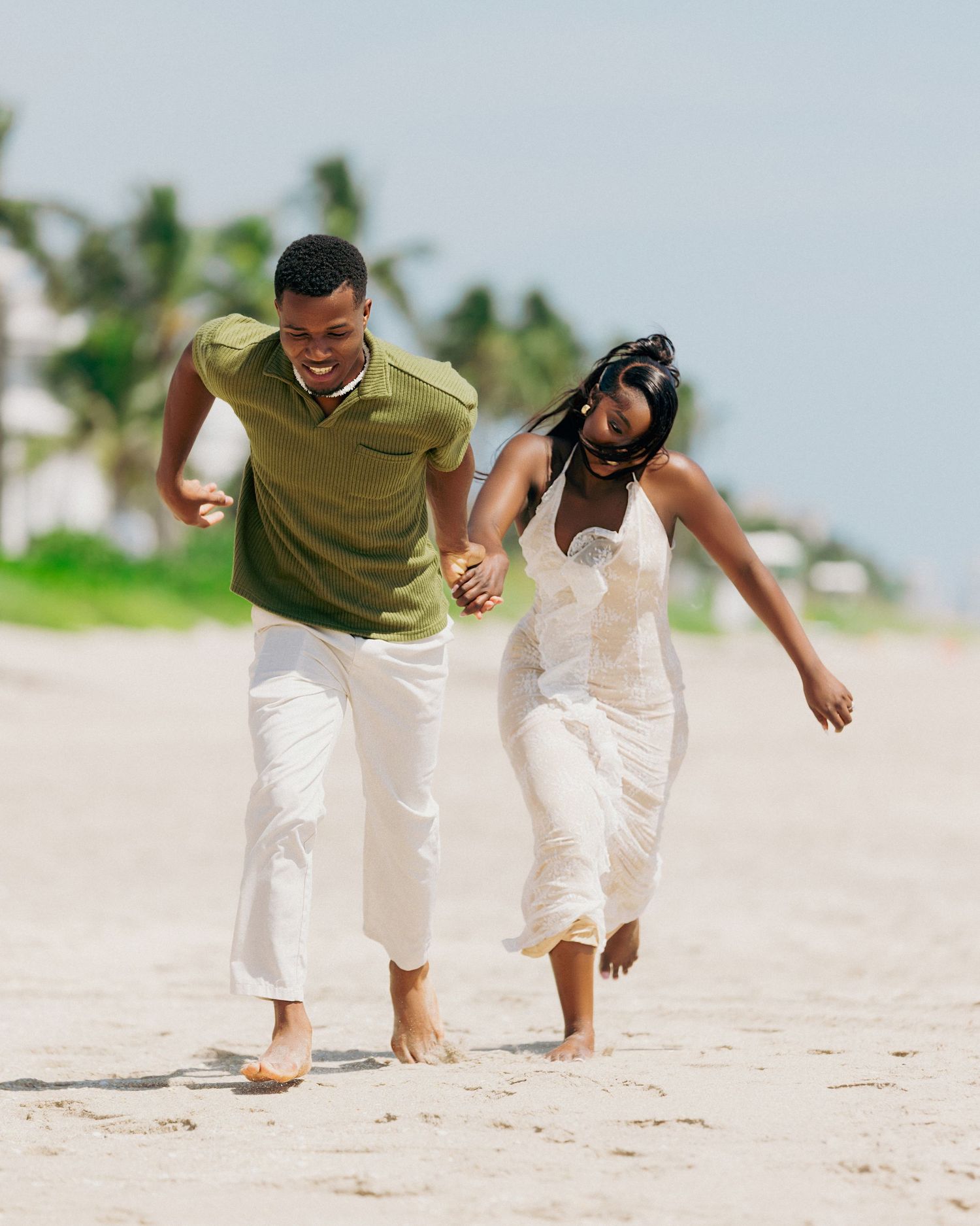 Couple in casual outfits playing and running together on a sunny beach.