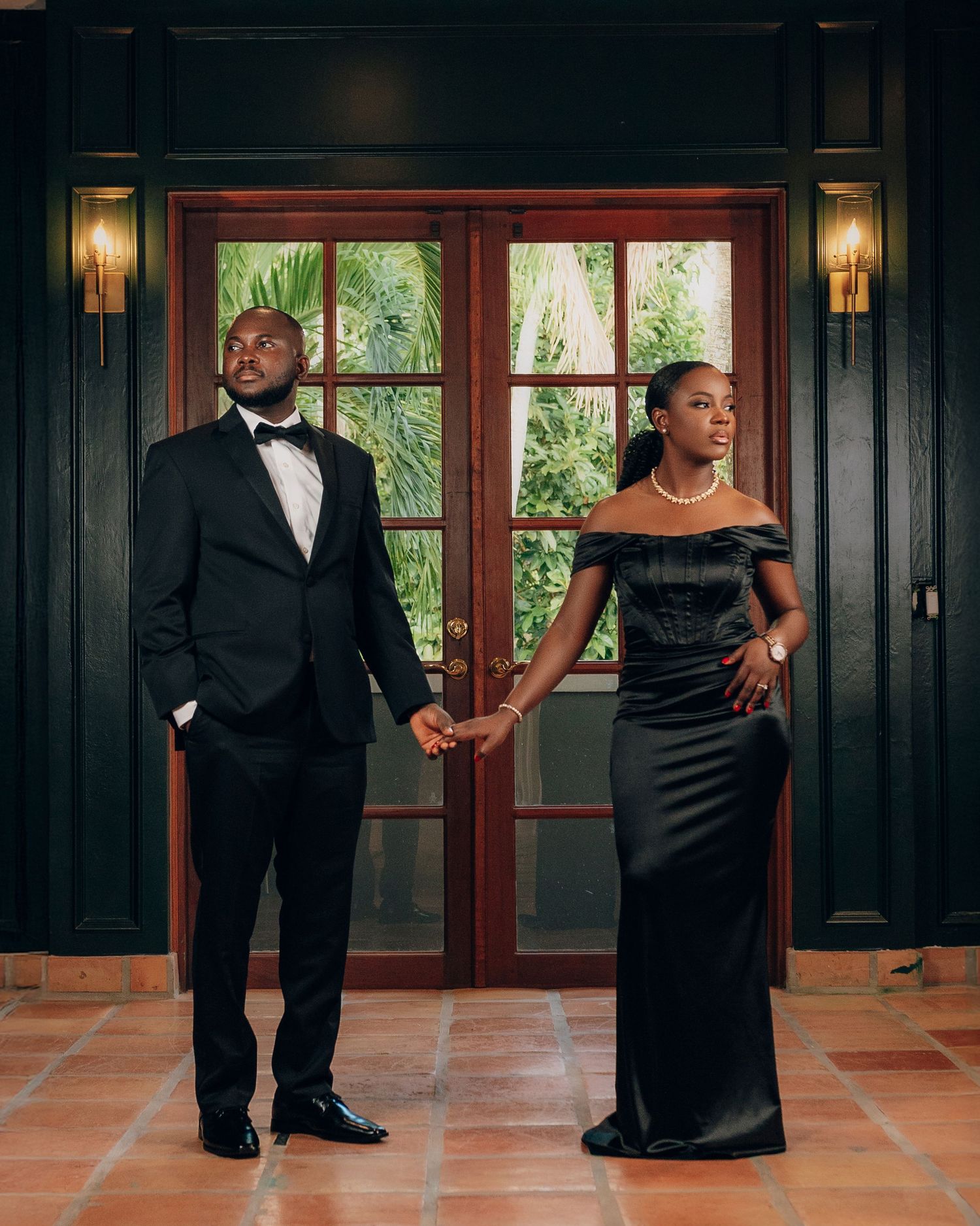 Couple in formal wear dances in elegant wood-paneled room.