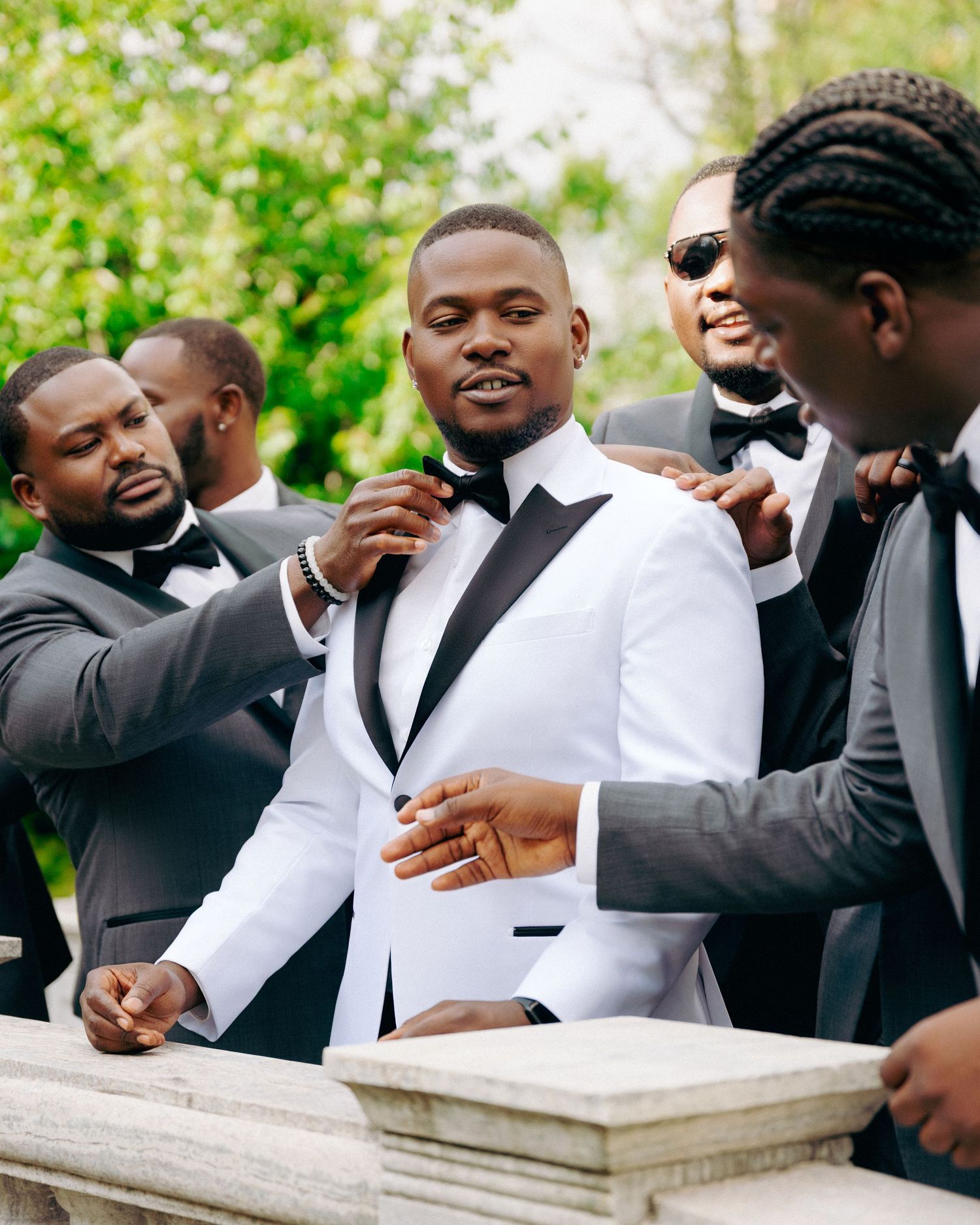 Groomsmen sharing laughs and candid moments during outdoor wedding photography session.