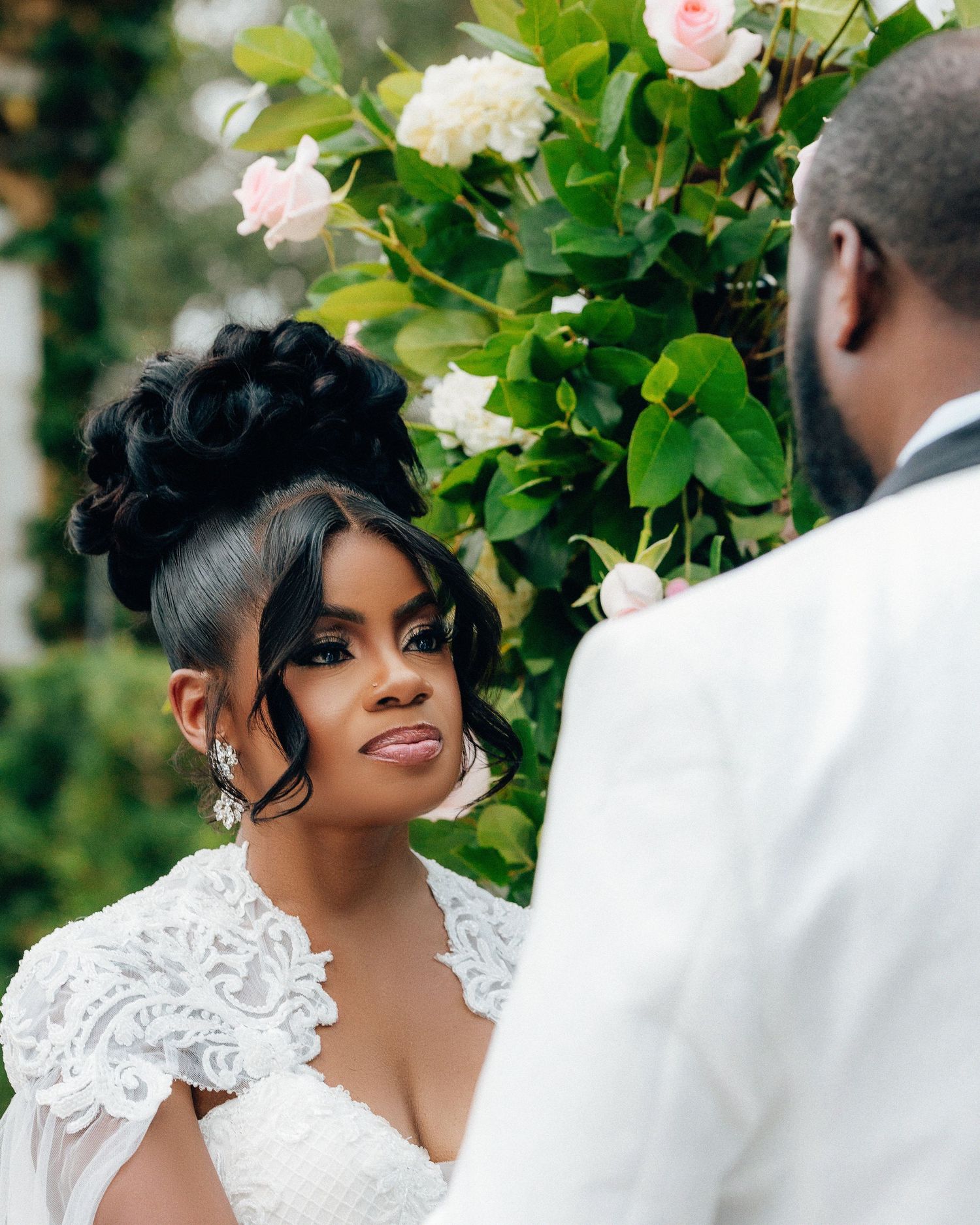 Beautiful wedding portrait series with pink roses and greenery in the background.