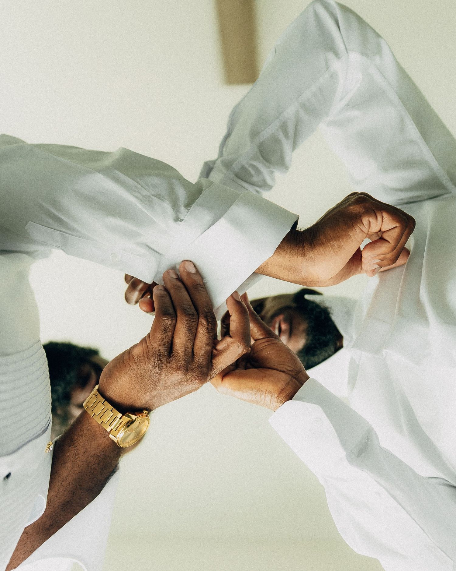 Close-up artistic shot of hands adjusting formal white attire.