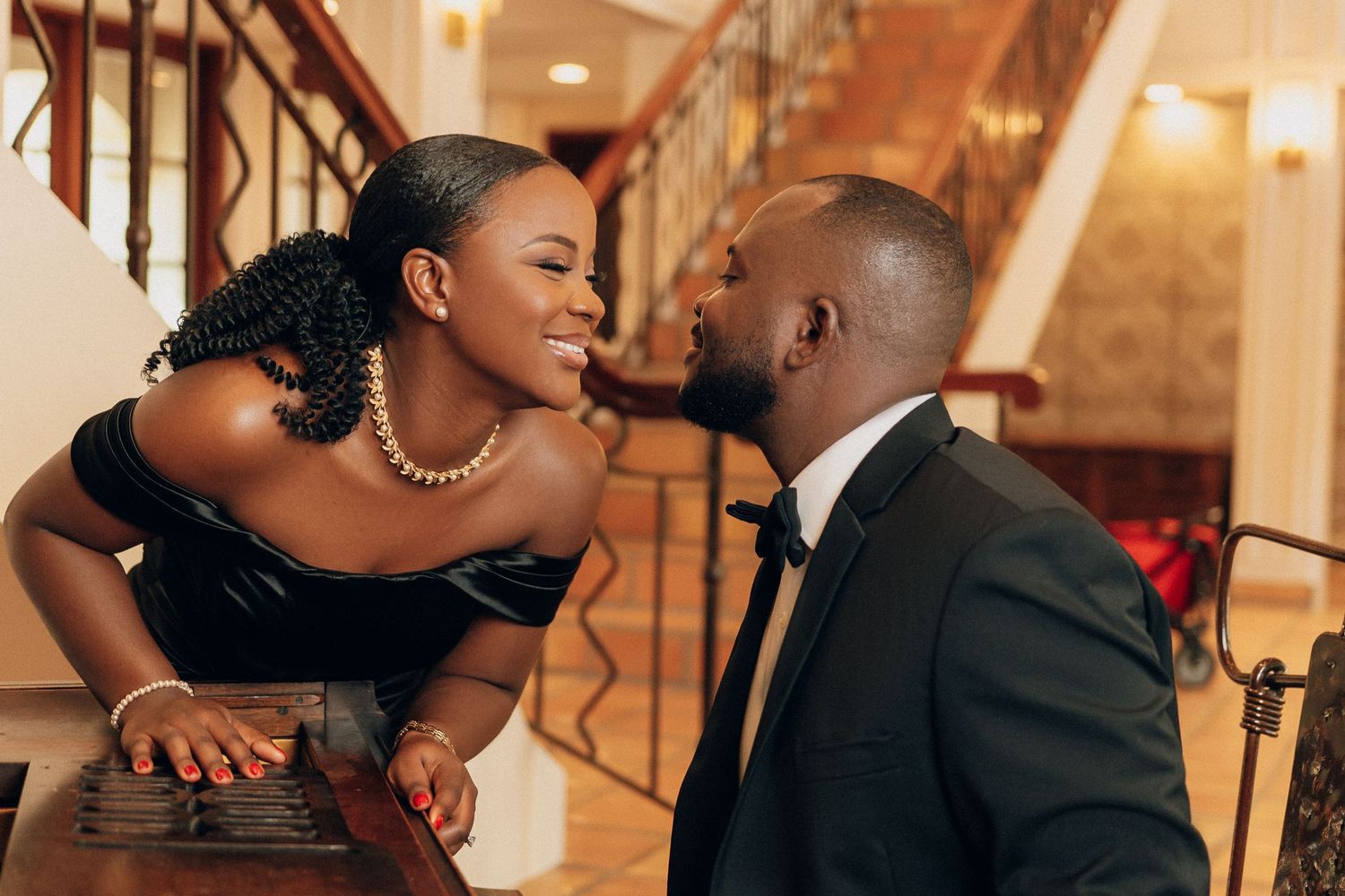 Couple shares intimate moments during formal indoor photoshoot.