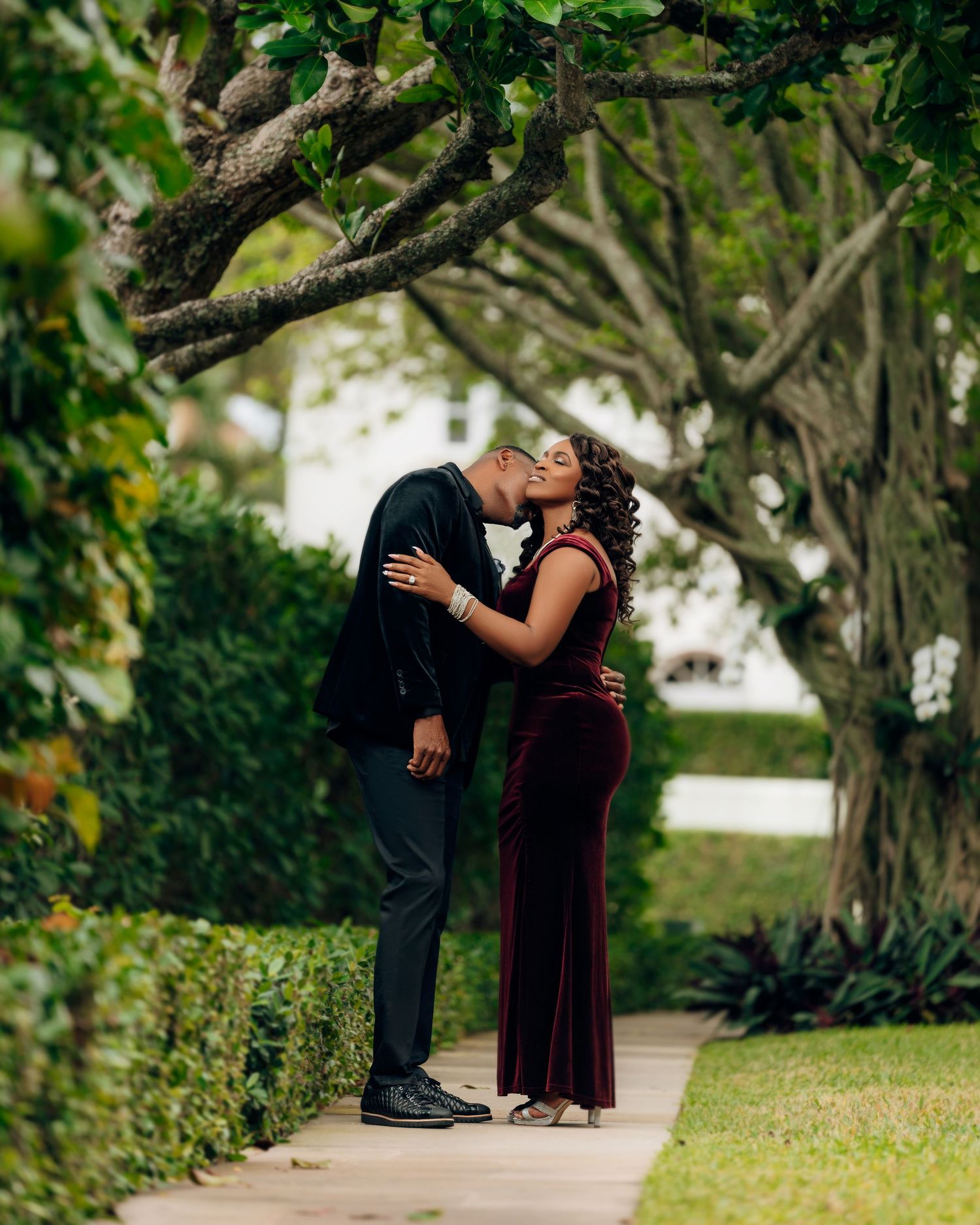 Romantic engagement photos of couple in a lush garden setting.