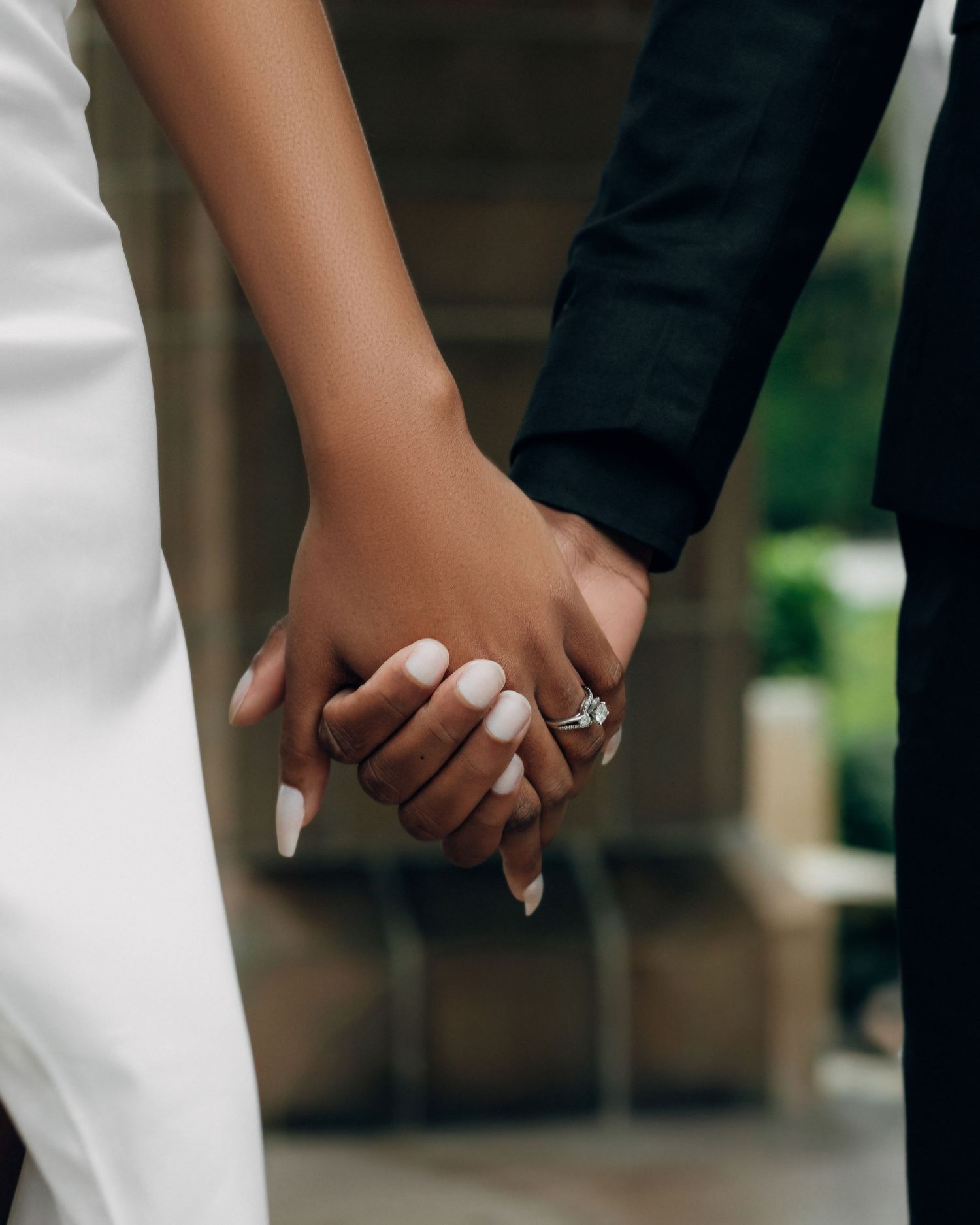 Close-up of hands tenderly clasped together in an intimate moment.