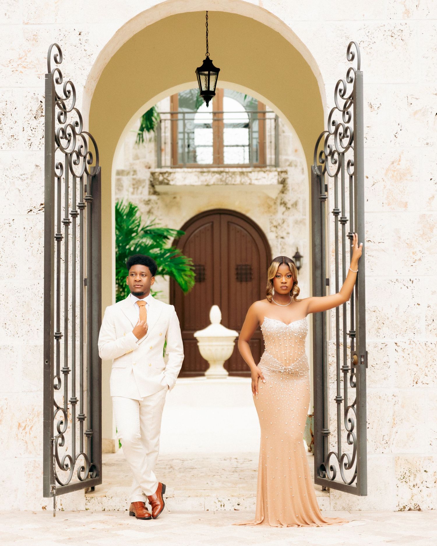 Elegant wedding photo series showing couples posing under ornate white stone archways with decorative iron gates.