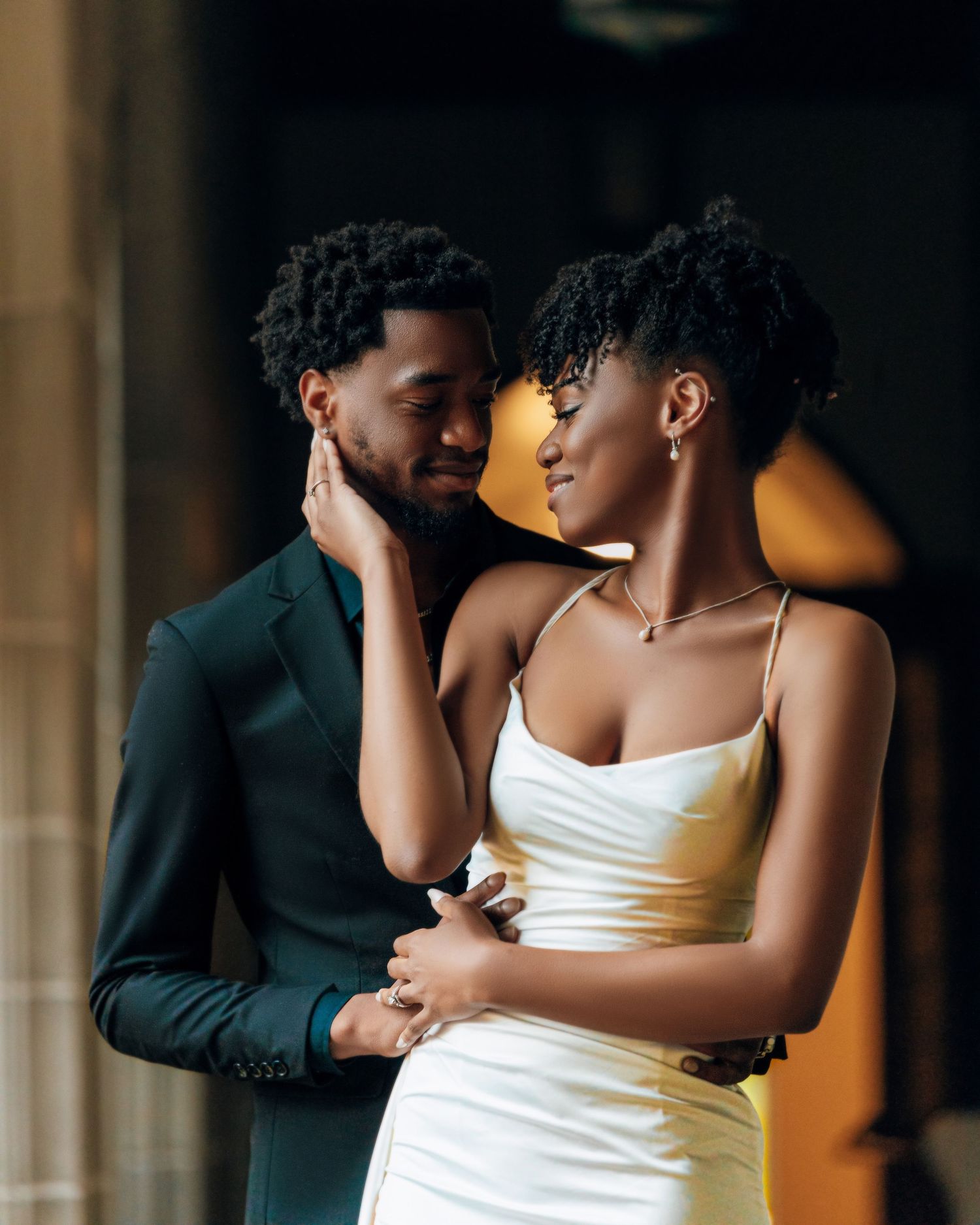 Intimate couple's portrait with dramatic lighting and shadows.
