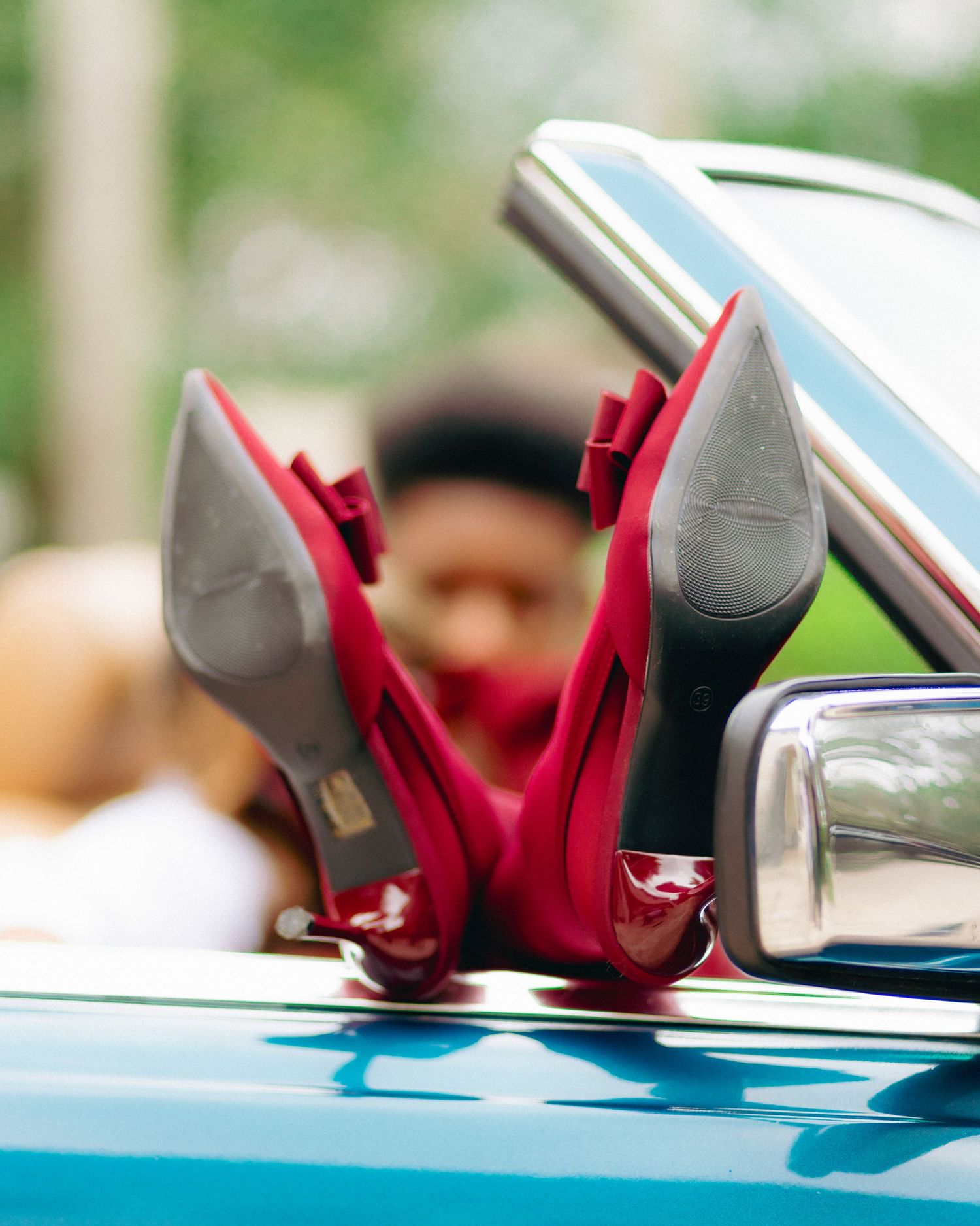 A sequence of four images showing a red convertible car top being lowered automatically in a sunny outdoor setting.