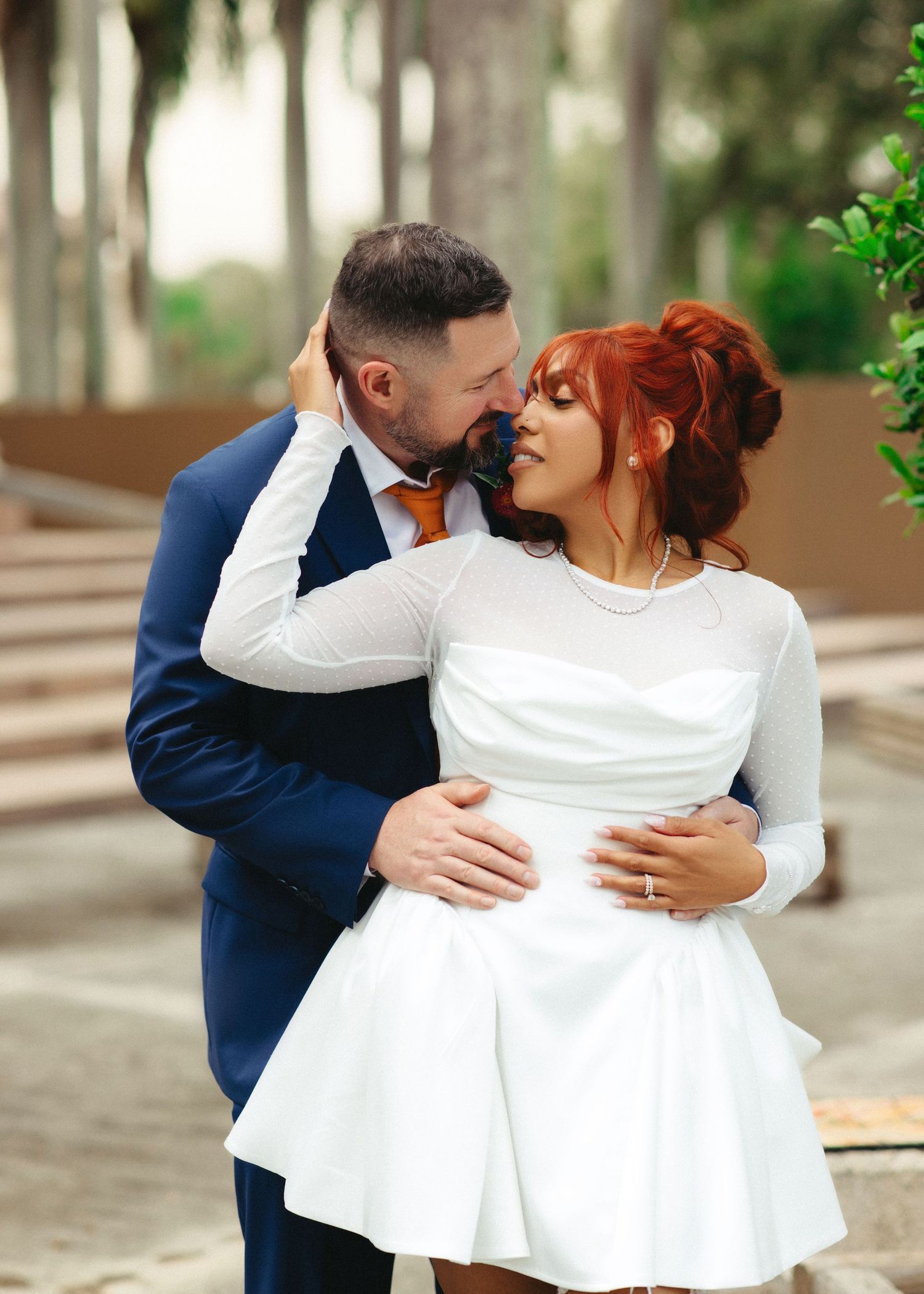 Romantic outdoor photo sequence capturing intimate moments between a couple in wedding attire among trees.